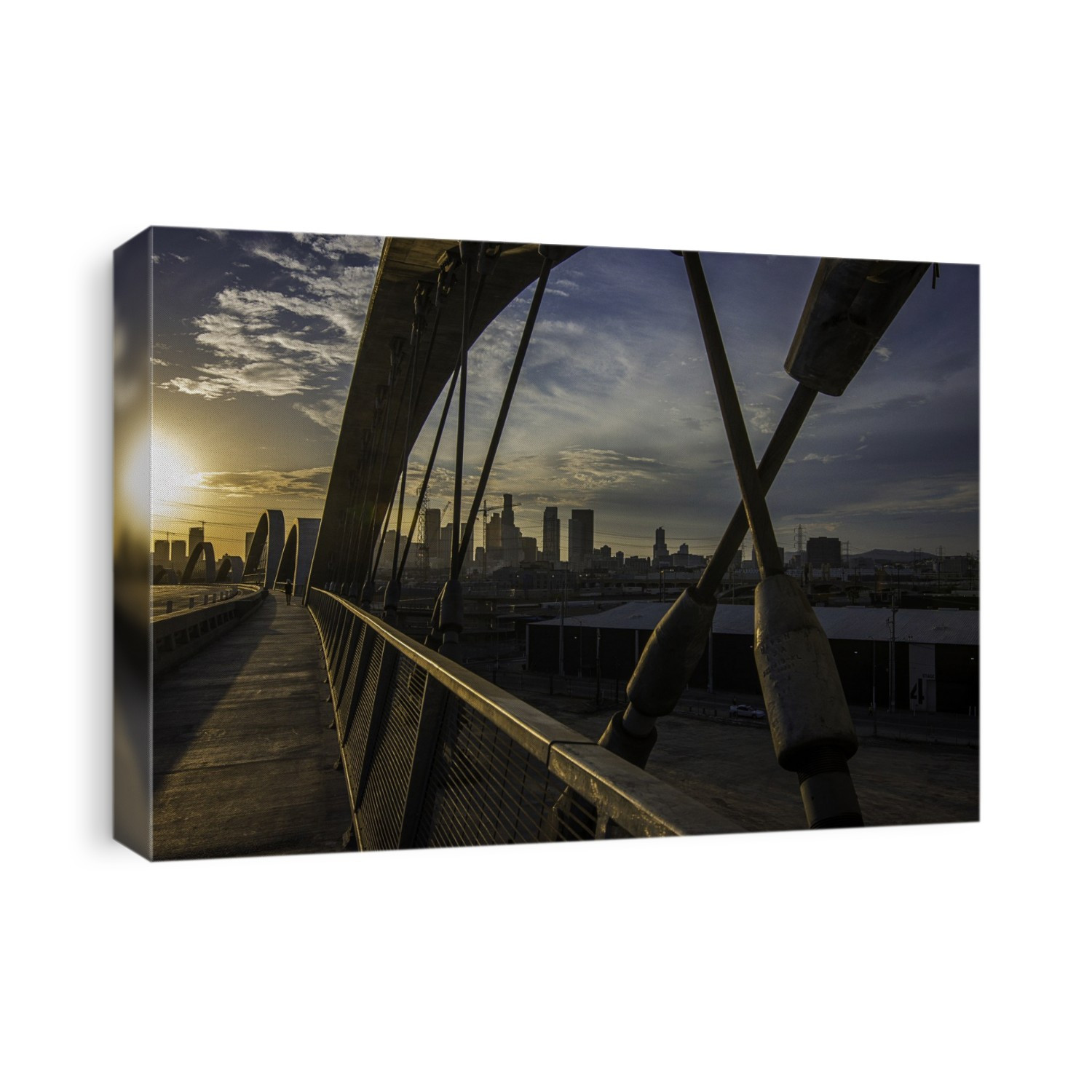 The Los Angeles skyling at sunset as seen through a support arch of the sixth street bridge.