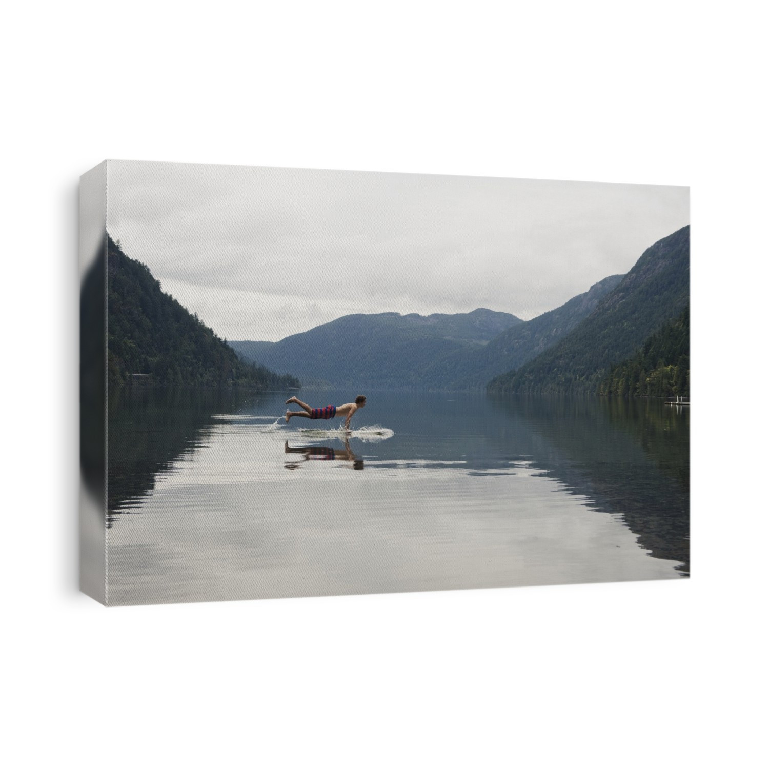 A Young Man Leaps Onto His Body Board In Cameron Lake; British Columbia Canada
