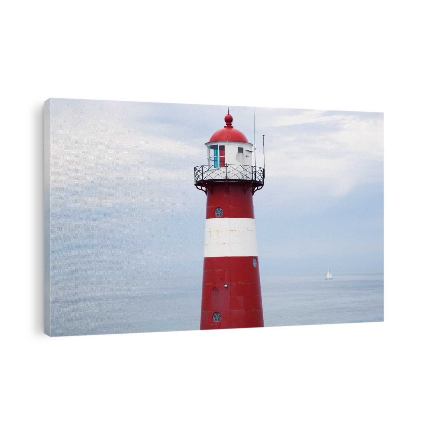 Red and white lighthouse along the coast with a sailboat in the distance near westkapelle; Zealand, netherlands