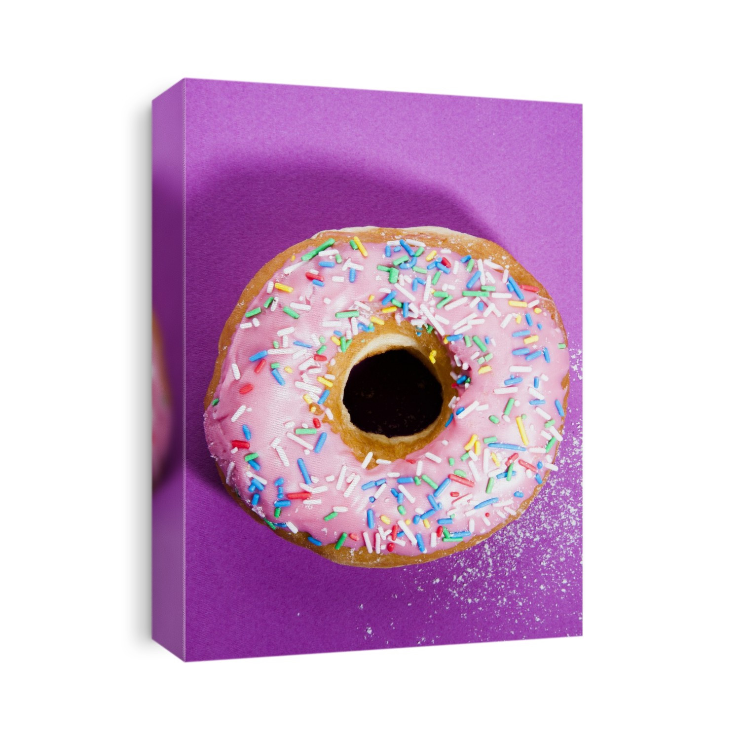 Pink doughnut with sprinkles against a pink background.