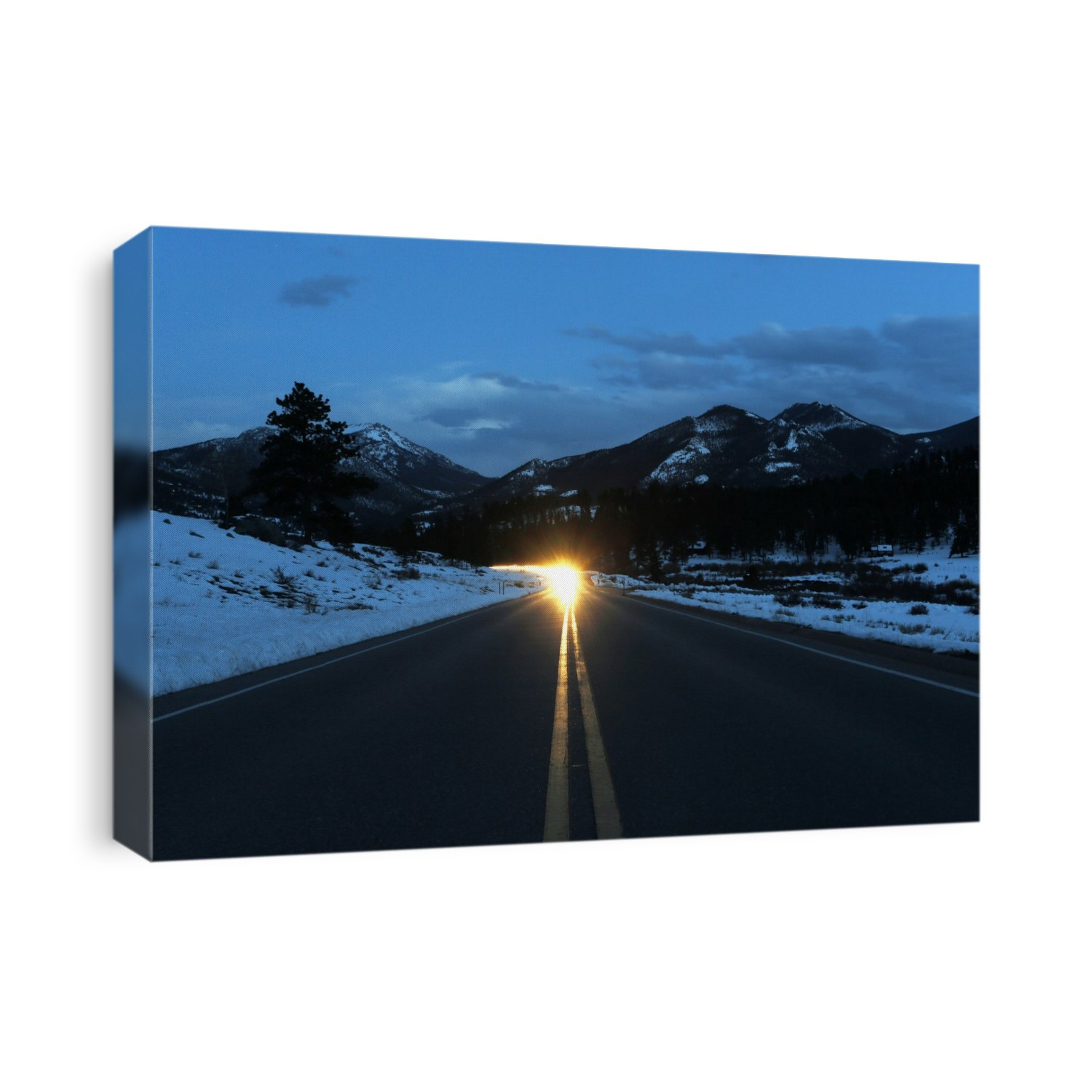 Rocky Mountains. View of approaching vehicle headlights on a road through Rocky Mountain National Park, Colorado, USA, at night.