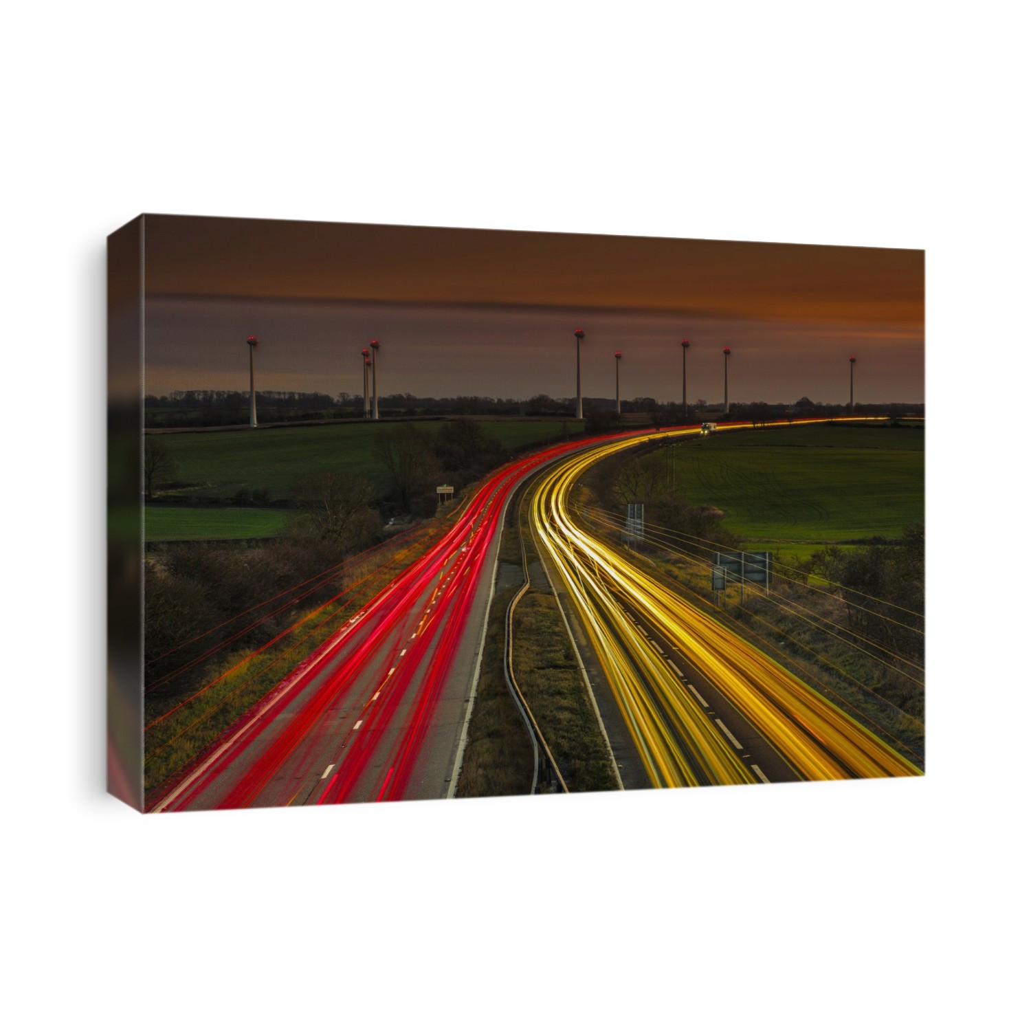 Light trails of vehicles on a busy dual carriageway at nightfall.