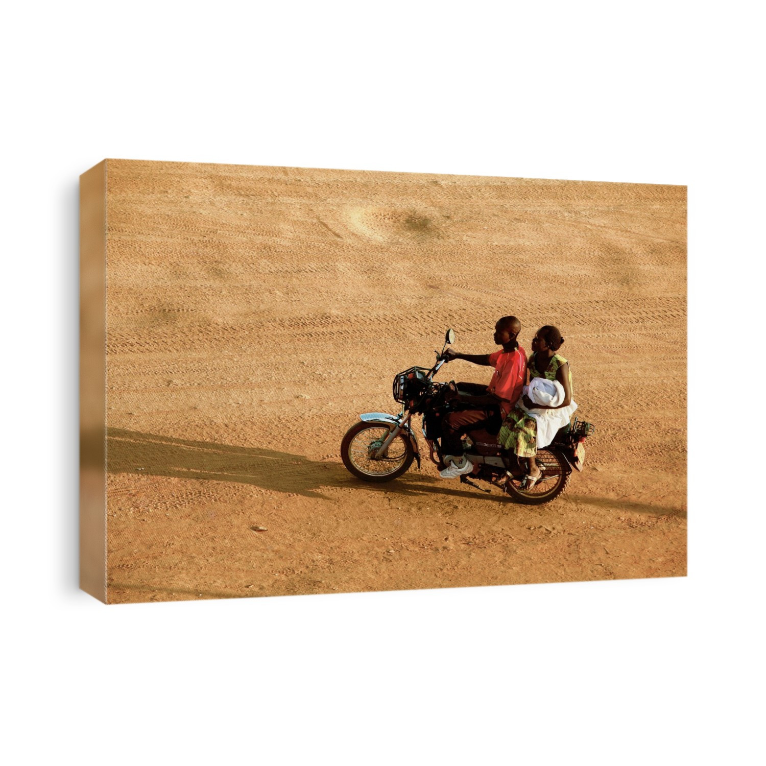 Riding a motorbike. Young man and a woman using a motorbike on an unpaved road. Photographed in Uganda.