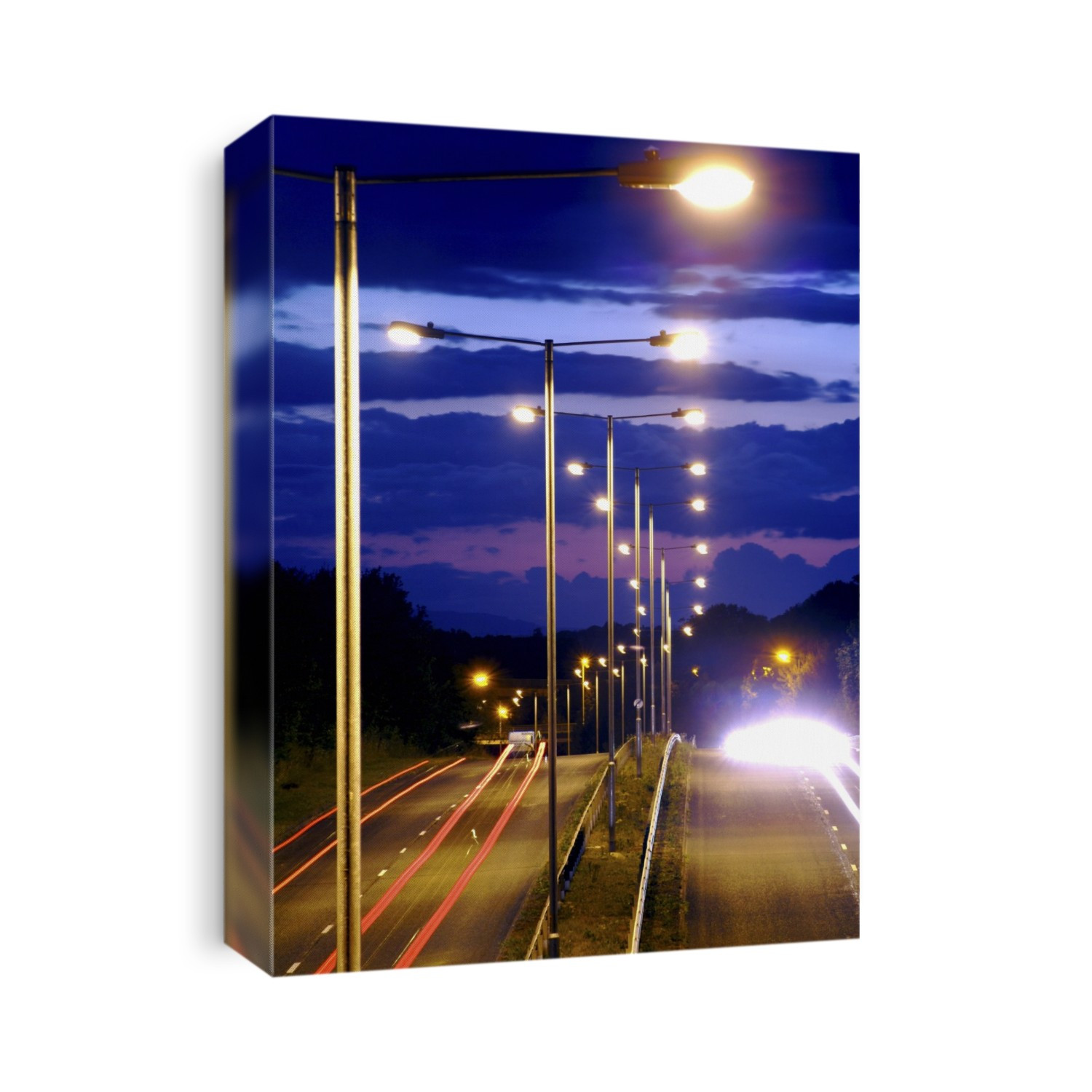 Dual carriageway street lighting. Time-exposure image of car lights and street lights along a dual carriageway. Each street light has a photoelectric switch that is sensitive to light. As the light levels fall as the Sun sets (as here), the switches triggers the lights, turning them on. Such switches are based on light-dependent resistors (LDRs). Photographed in the UK.