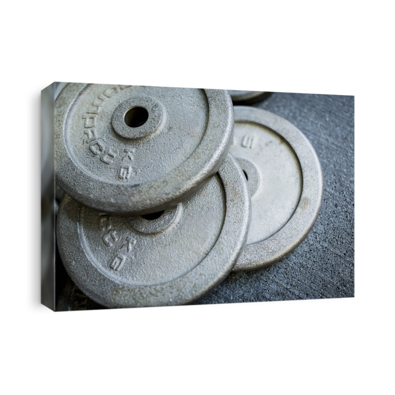 Close-up of heavy weight plates on the ground.