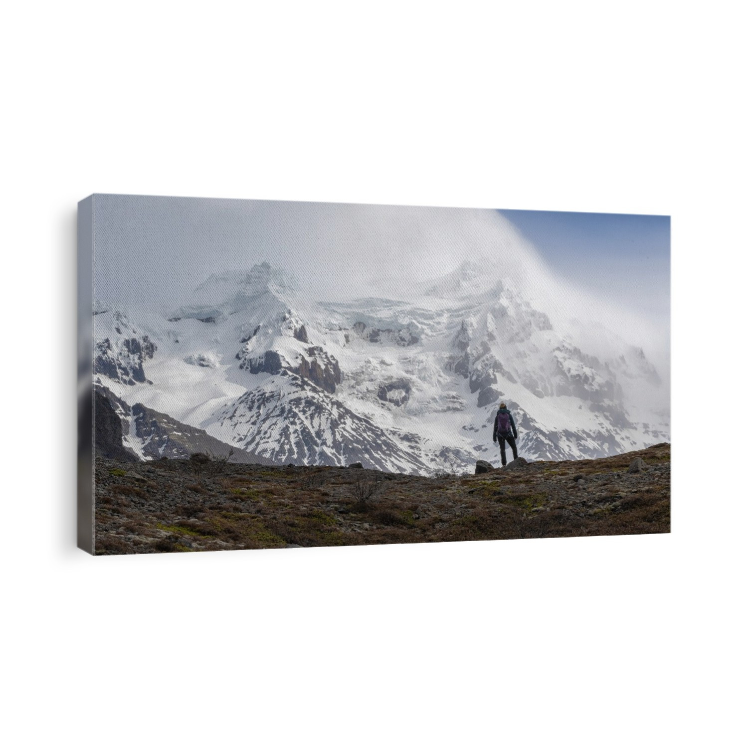 Woman standing in the drizzle in front of an imposing mountain with a glacier on it in Southern Iceland; South Coast, Iceland