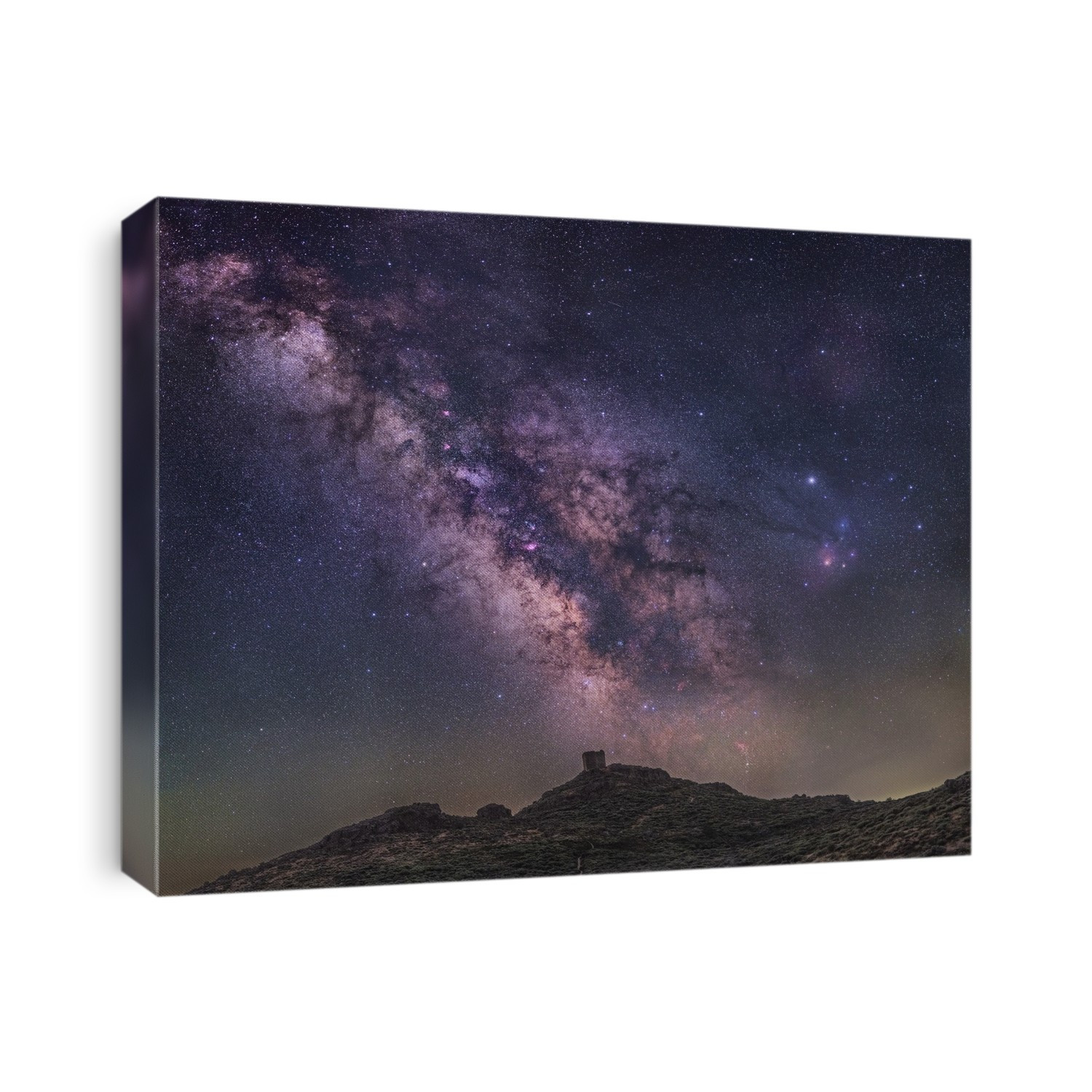 Milky Way over a castle. The Milky Way is our galaxy seen from the inside, forming a band of stars and nebulae stretching across the sky. Across bottom is a castle on a skyline in Spain.
