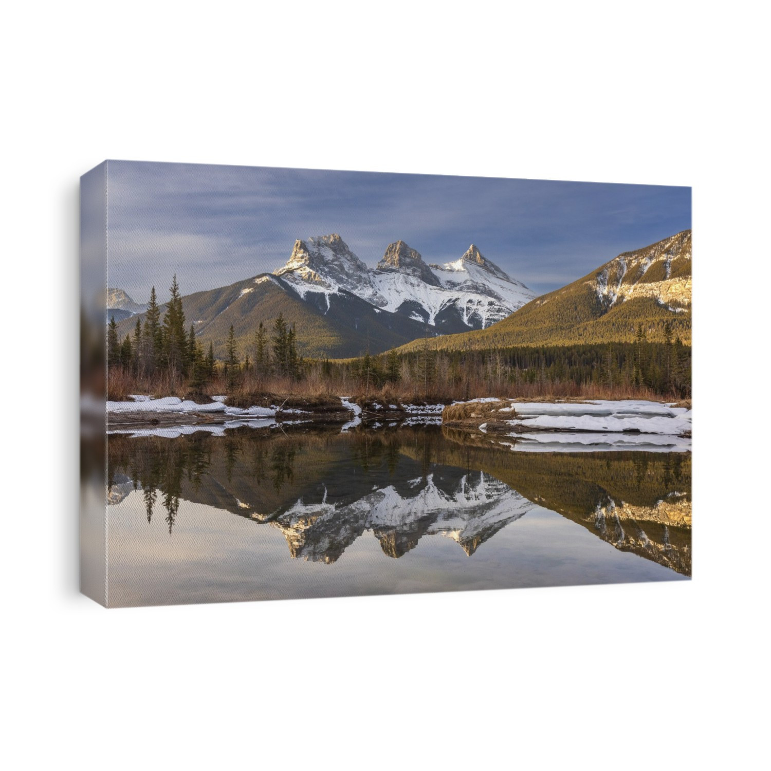 Three Sisters snow-capped mountain peaks reflected in a mirror image in a lake in Alberta, Canada; Canmore, Alberta, Canada