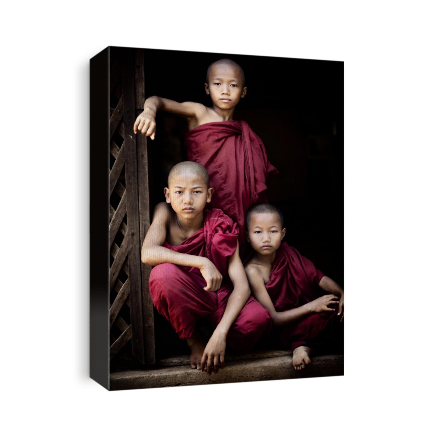 Portrait of three young Burmese monks boys in their monastery