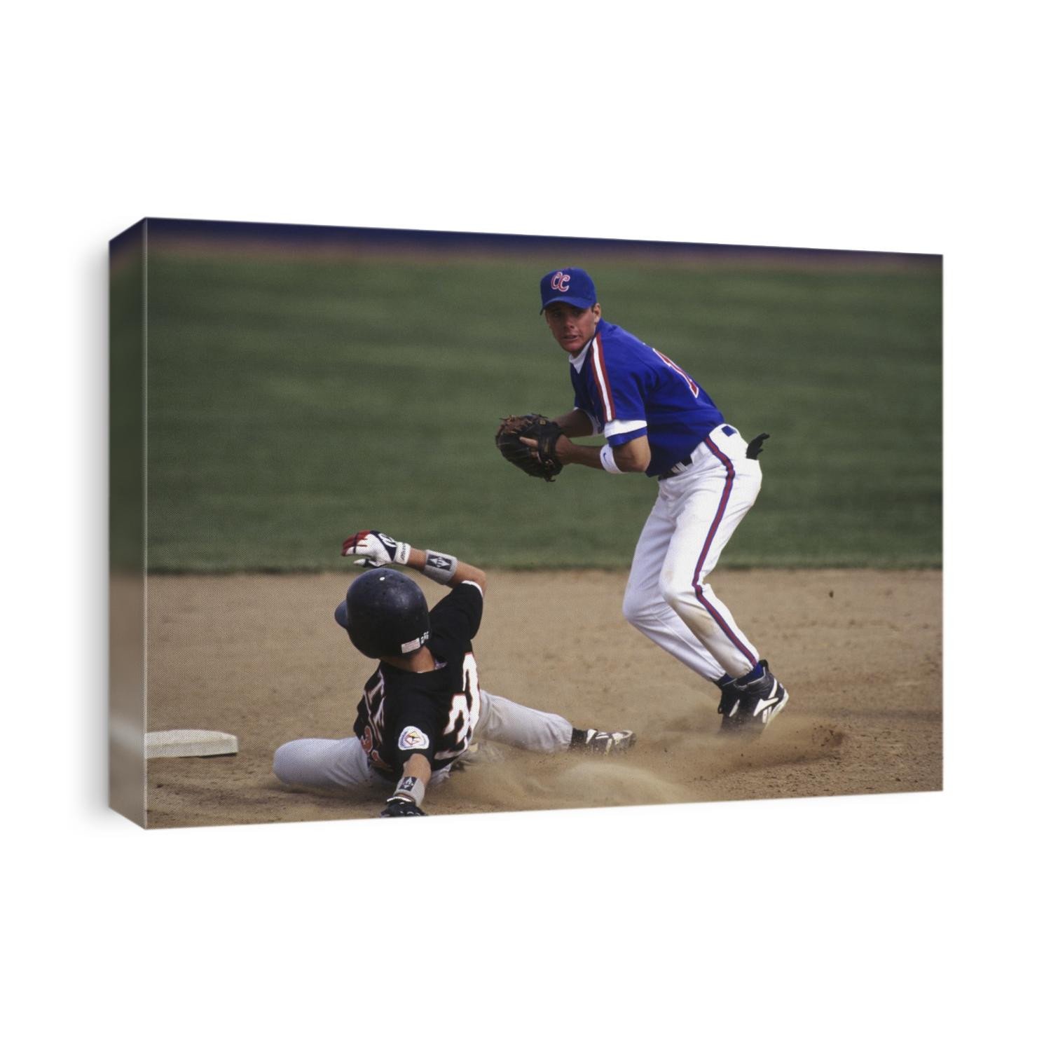 Baseball player sliding into second base.
