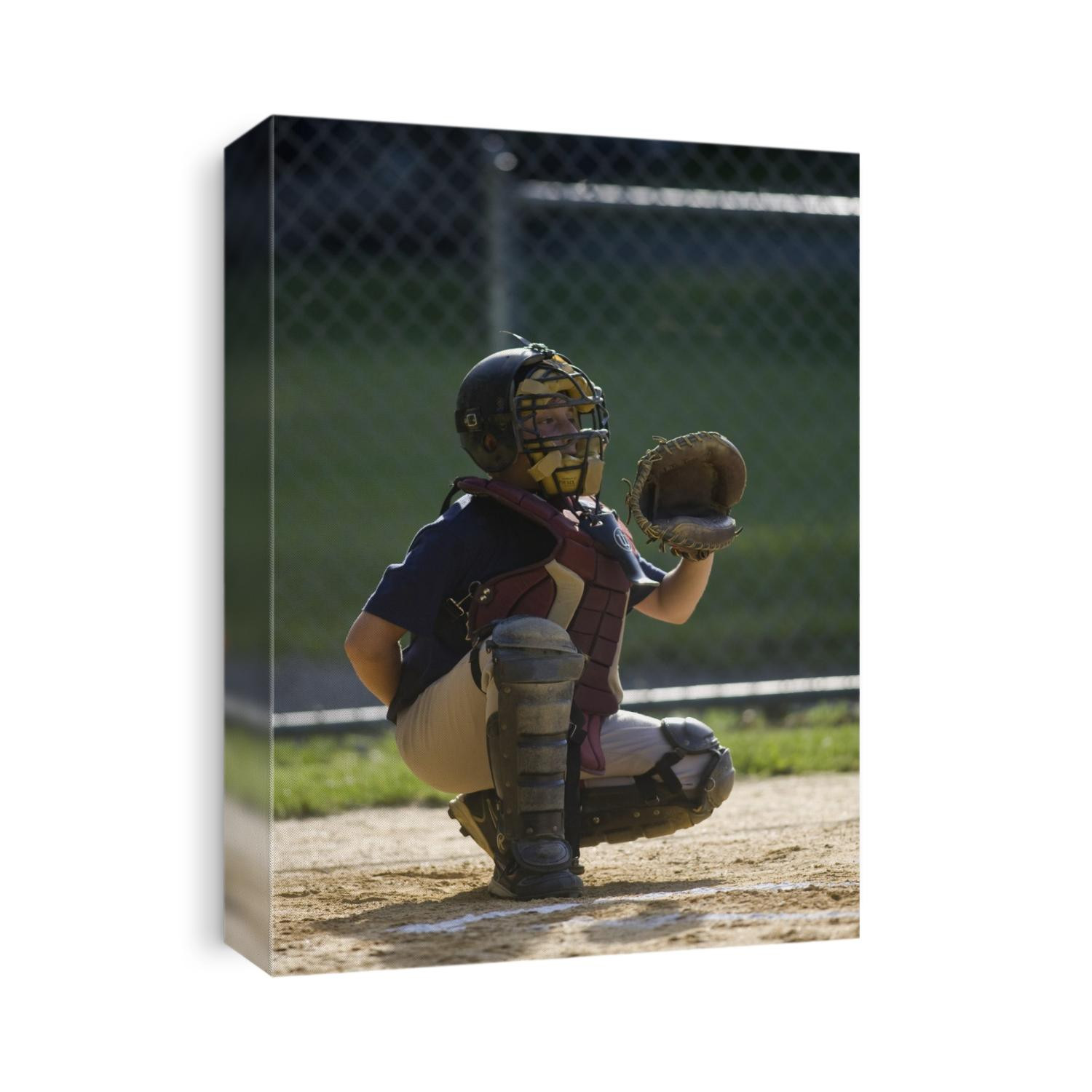 10 year old boy catching during baseball game.