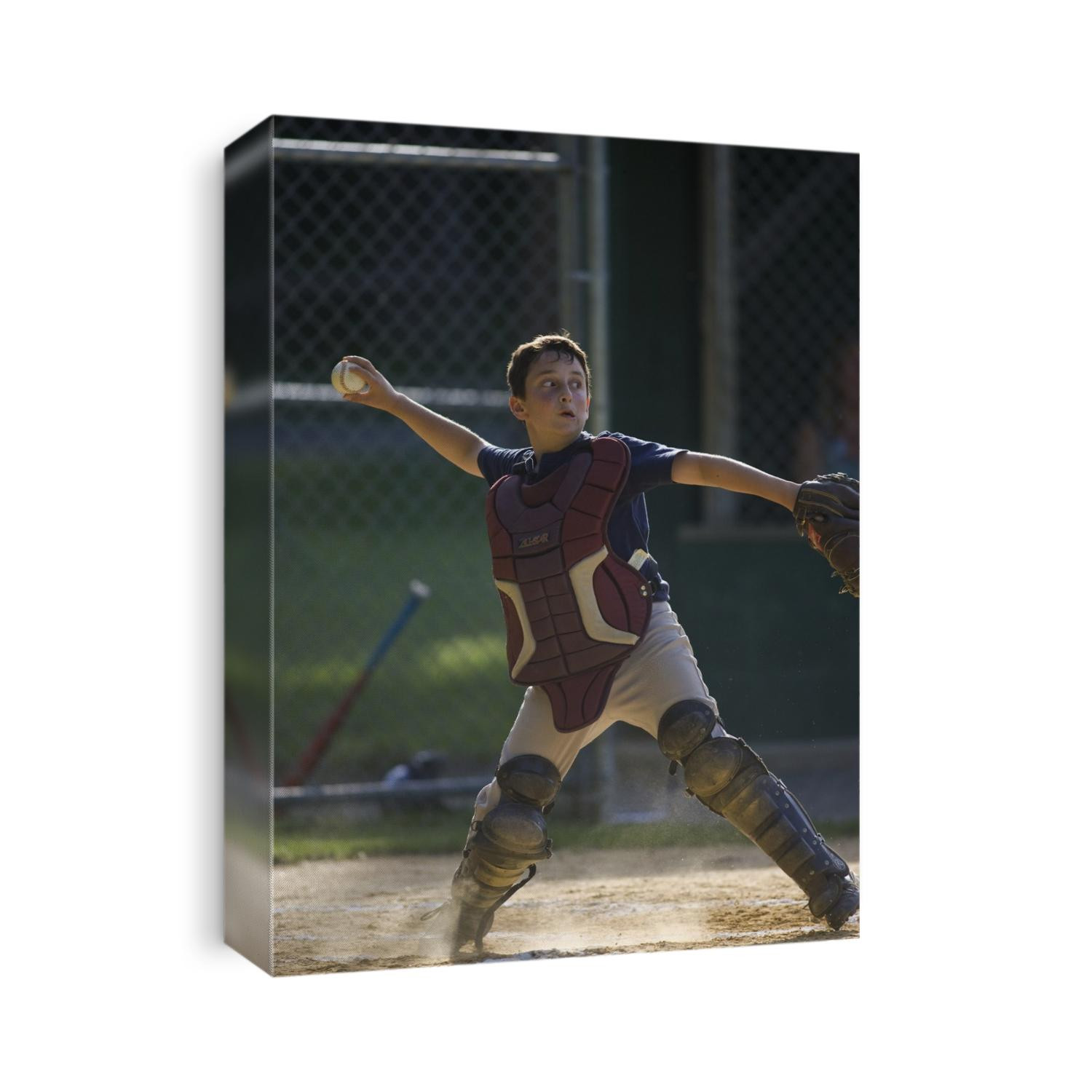 10 year old boy catching during baseball game.