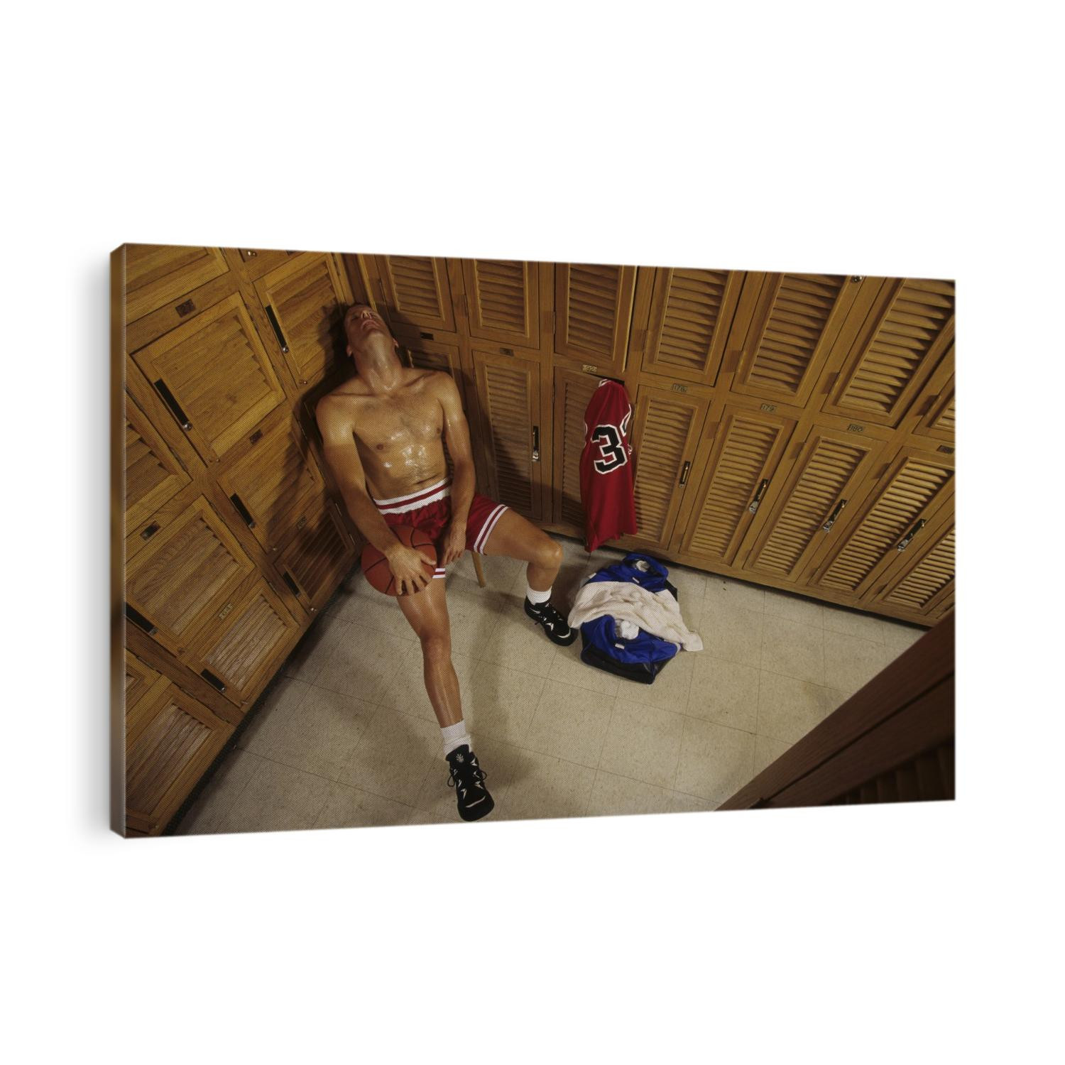 Man resting in locker room after basketball workout.