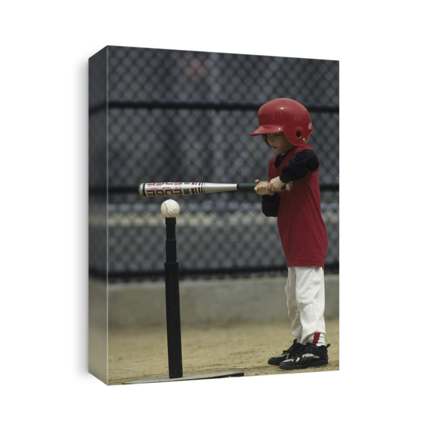 Young boy batting during a tee ball game.