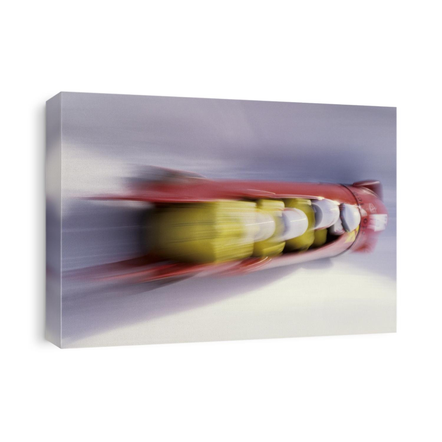 Blurred action of 4 man bobsled team.