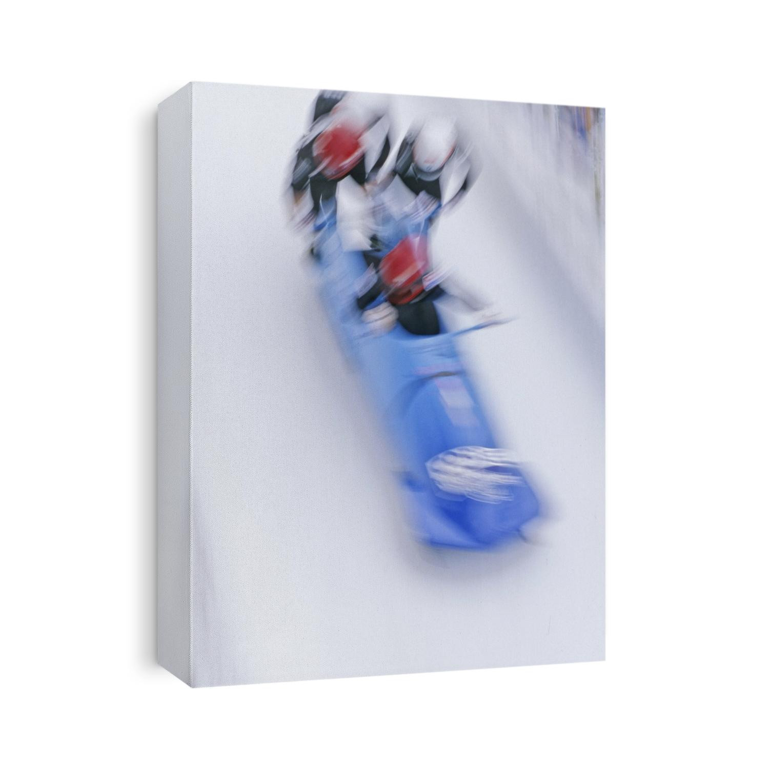 Blurred action of 4 man bobsled team pushing off at the start.