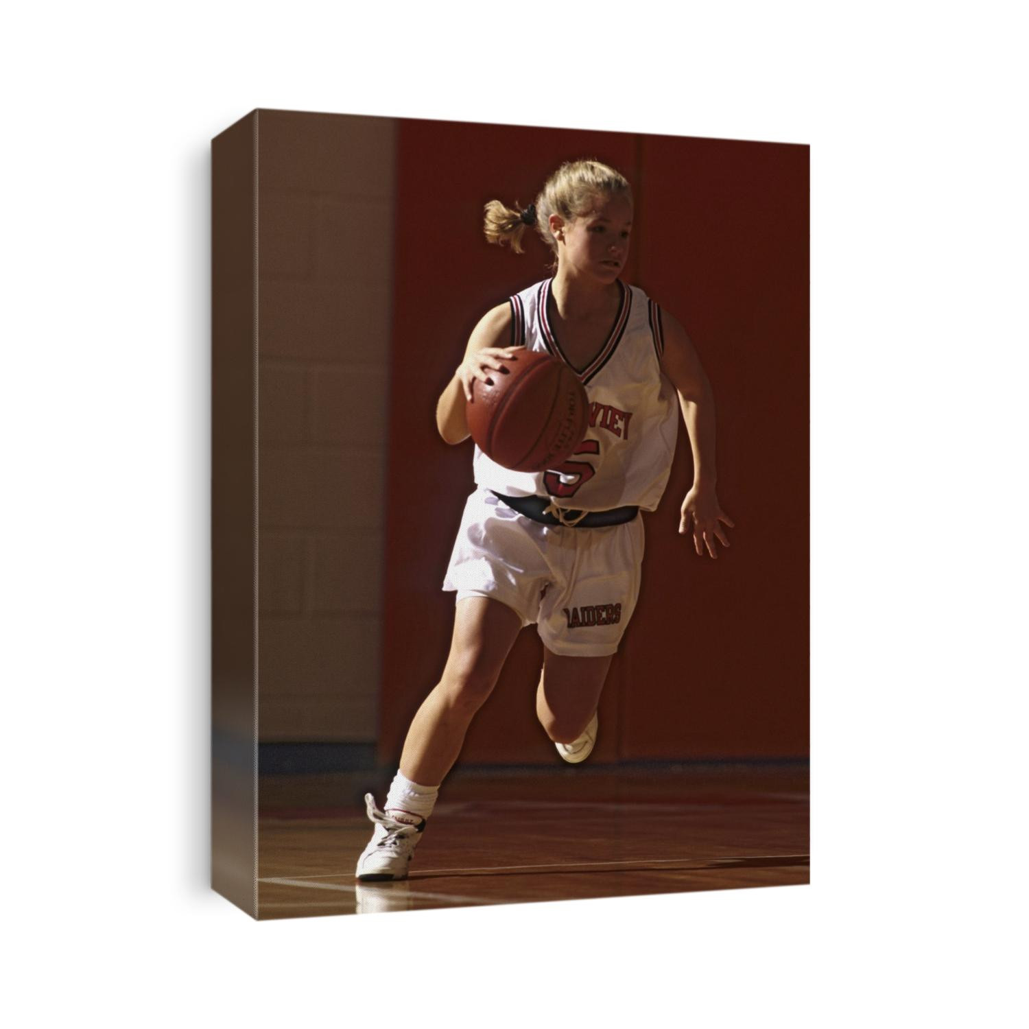 Female High School basketball player in action during a game.
