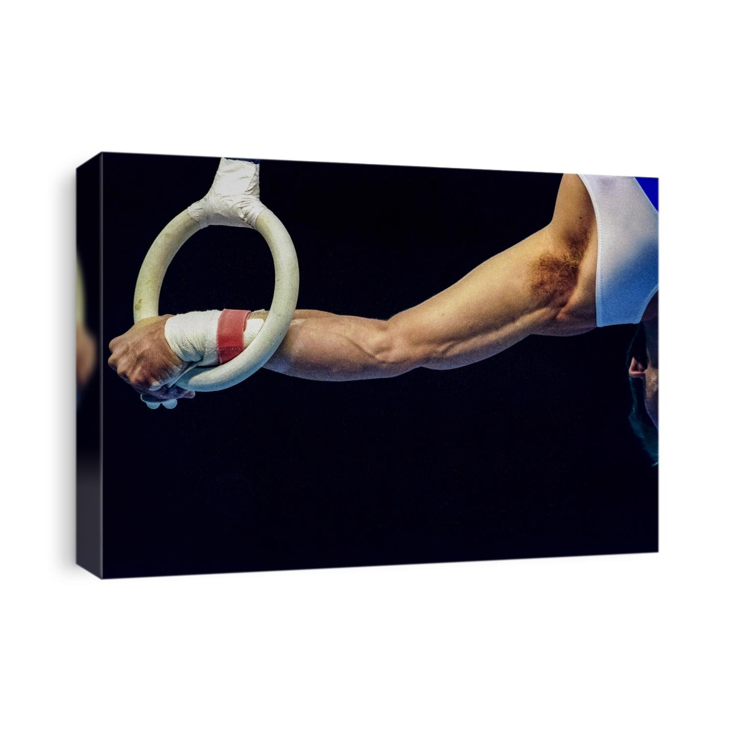 Male gymnast preforms on the rings.