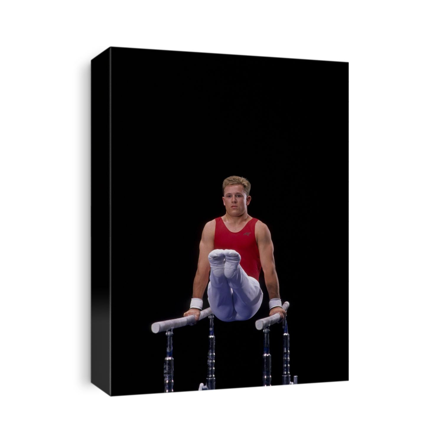 Male gymnast on the parallel bars.