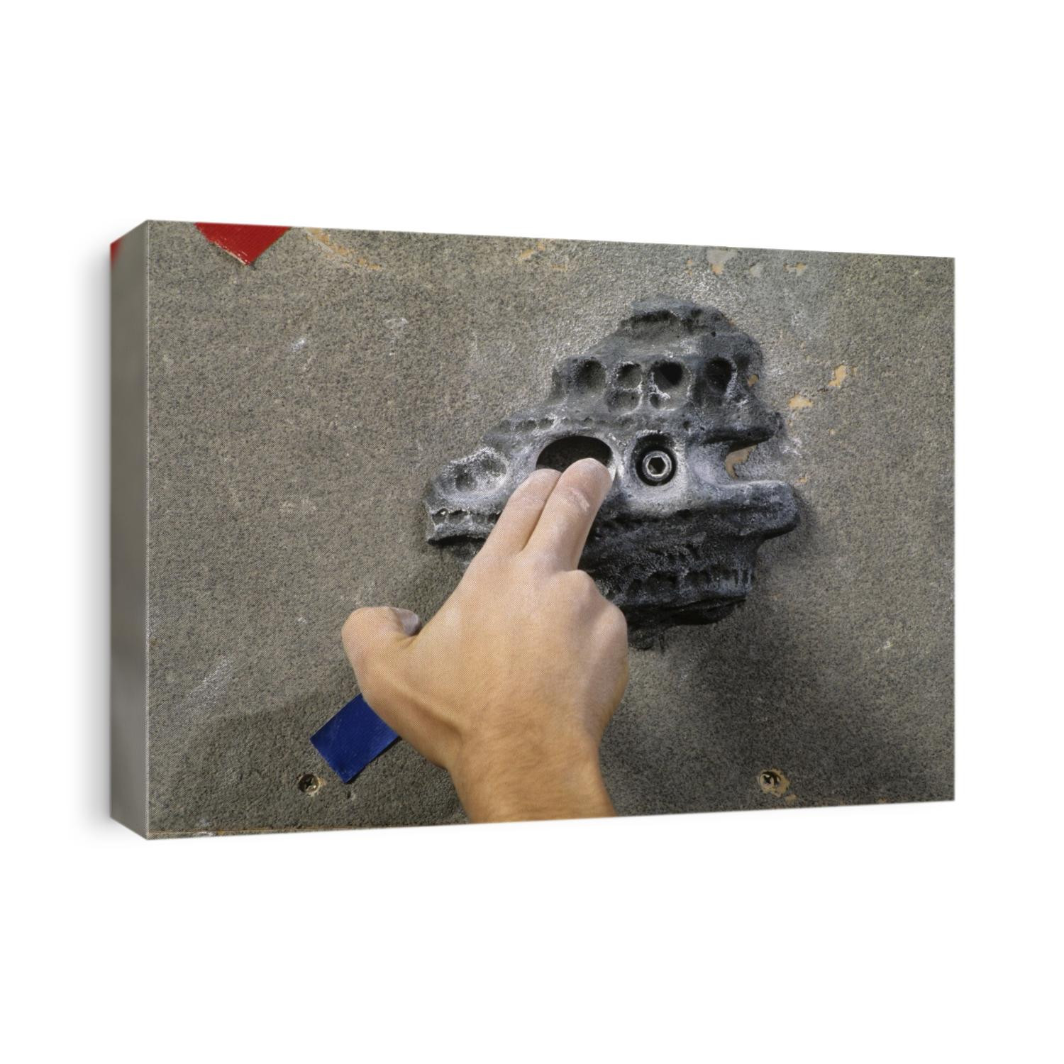 Detail of hand on wall climbing grip.