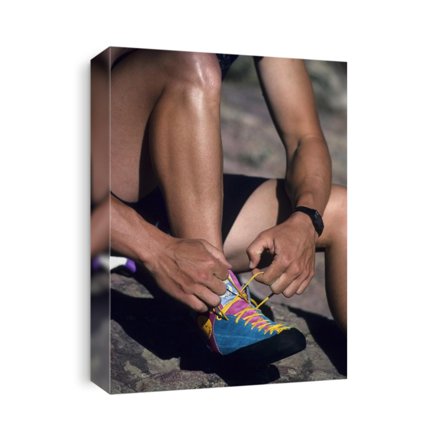 Rock climber tying his shoes (detail).