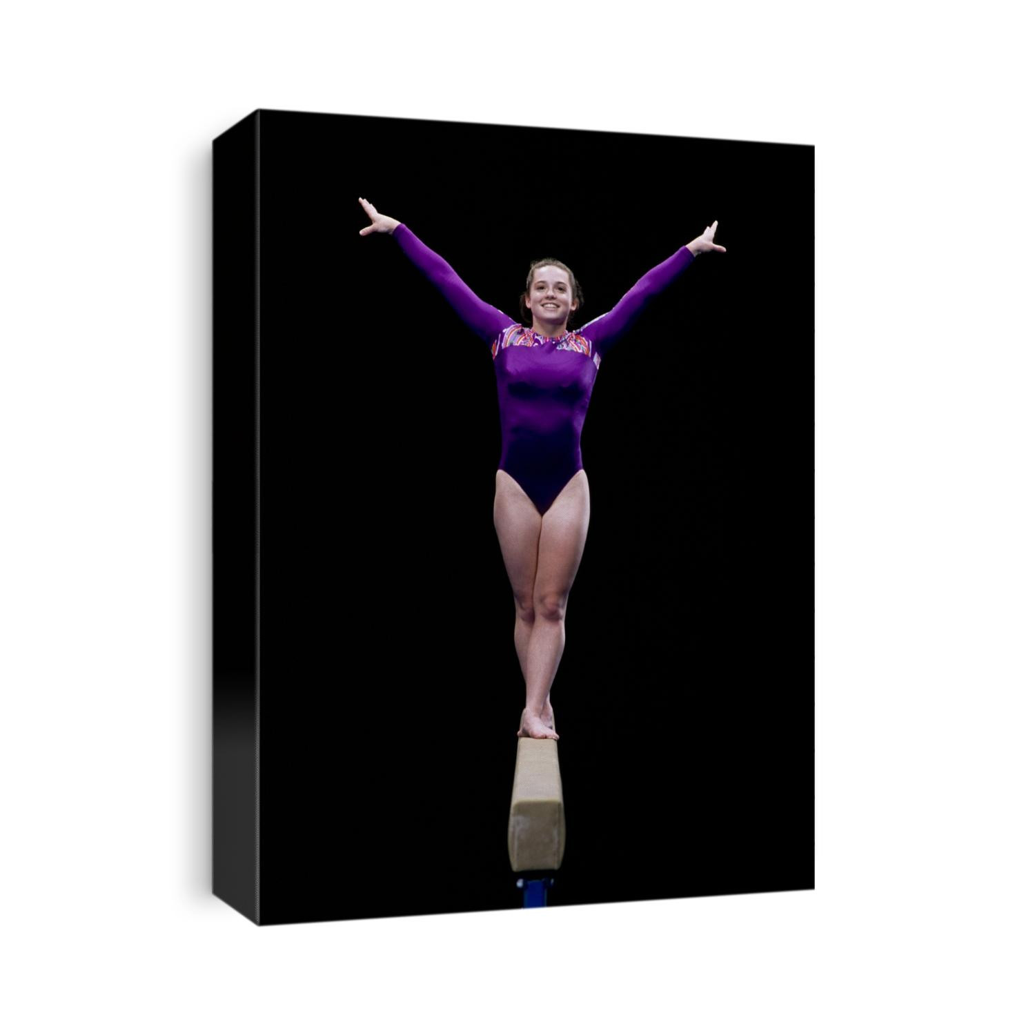 Female gymnast performing on the balance beam.
