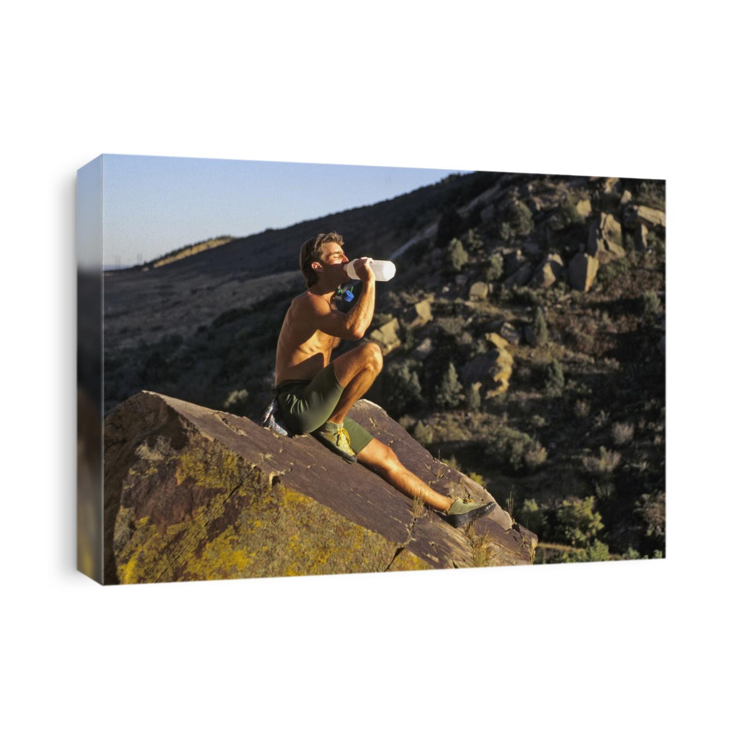 Male rock climber drinking during a rest break.