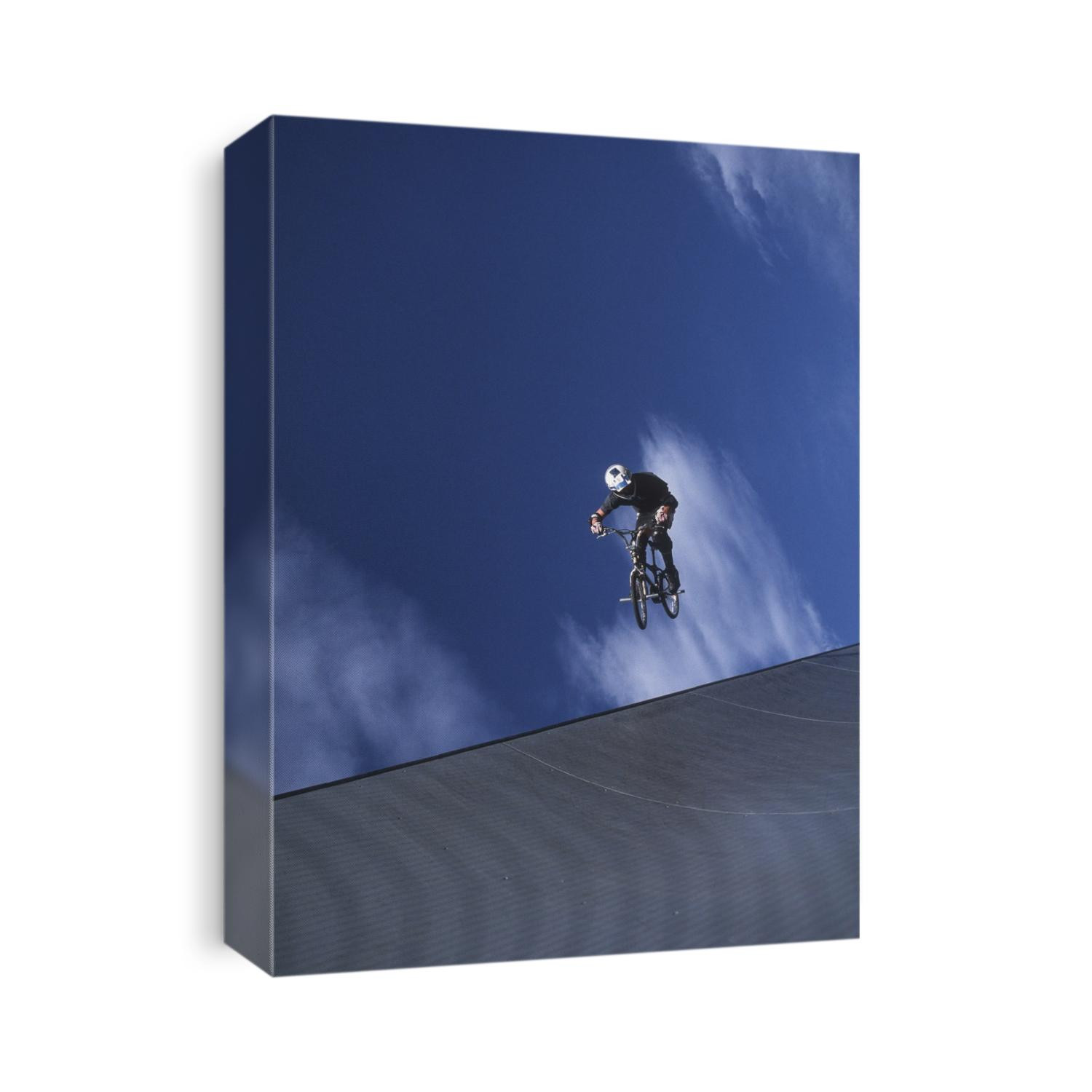 Teenage boy flys over the vert on a BMX bike.