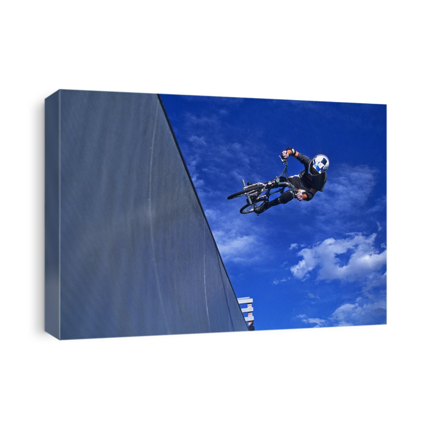 BMX cyclist flys over the vert.
