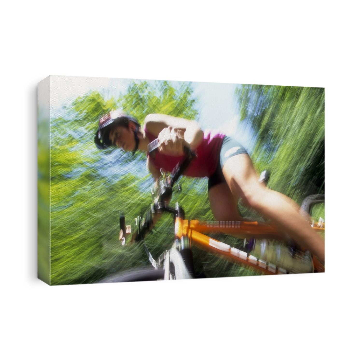 Young female recreational mountain biker riding in the forest.