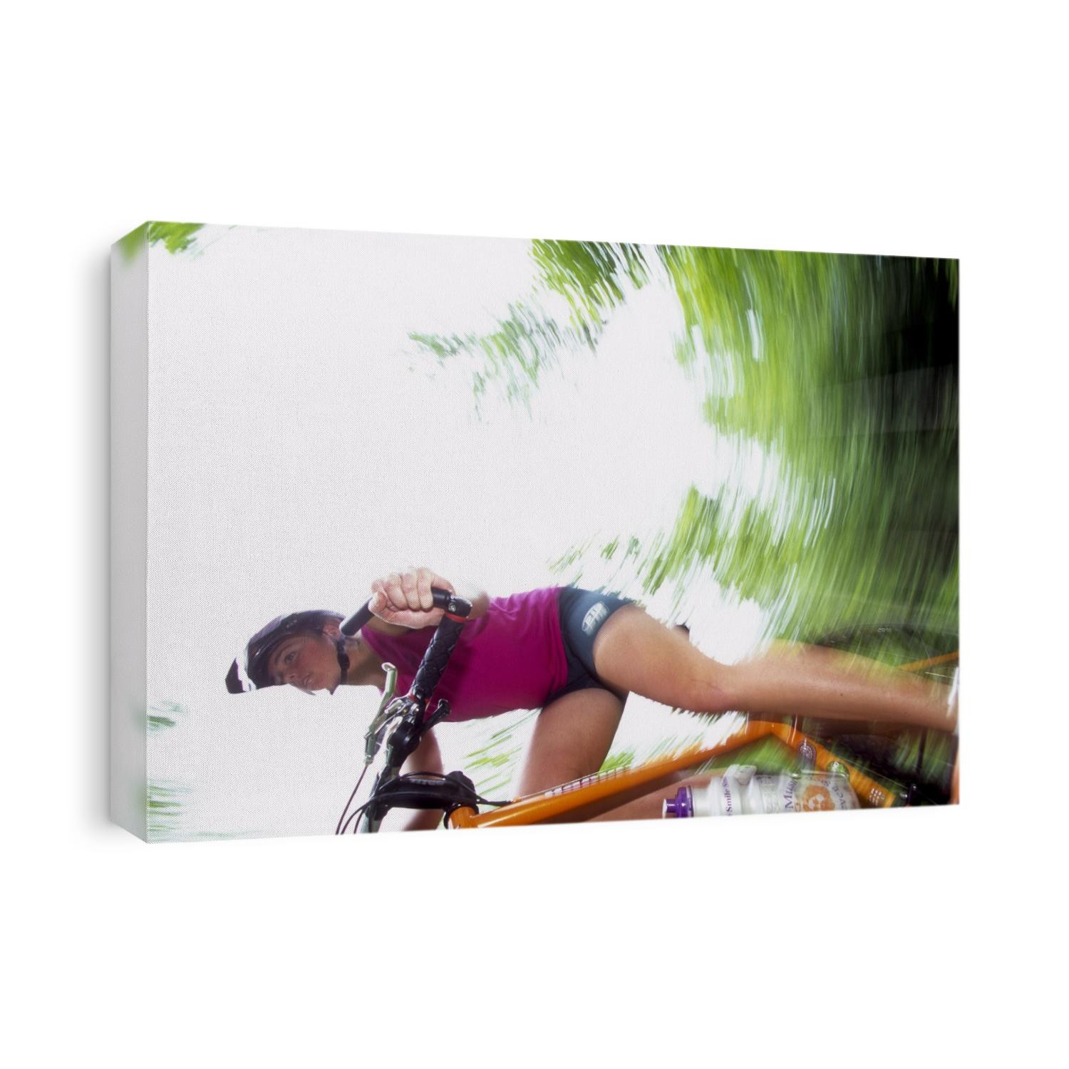 Young female recreational mountain biker riding in the forest.