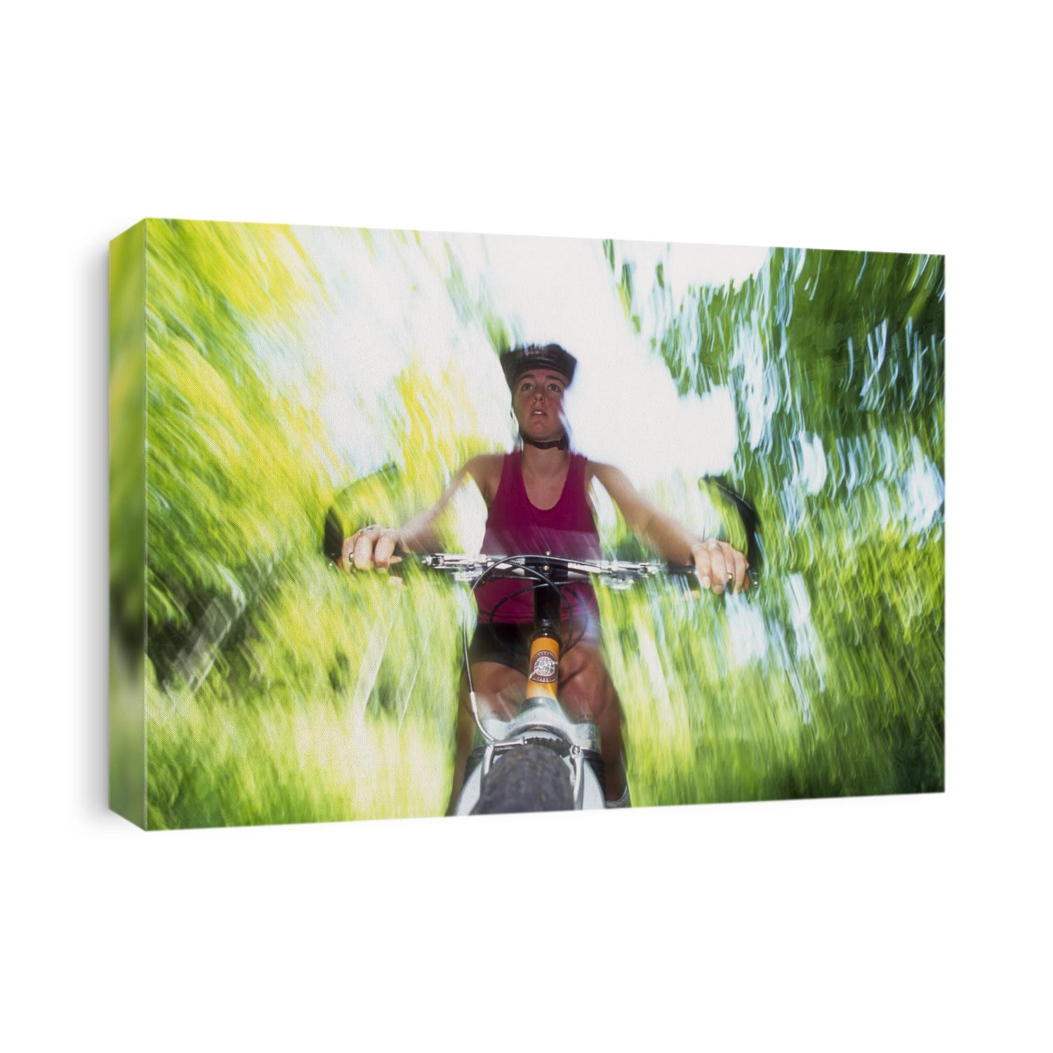 Young female recreational mountain biker riding in the forest.