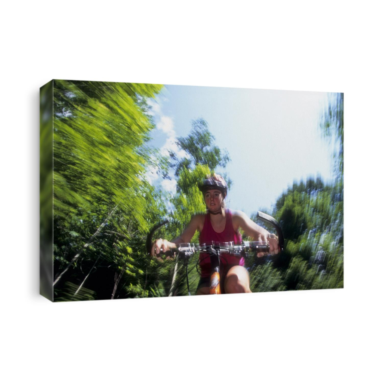 Young female recreational mountain biker riding in the forest.