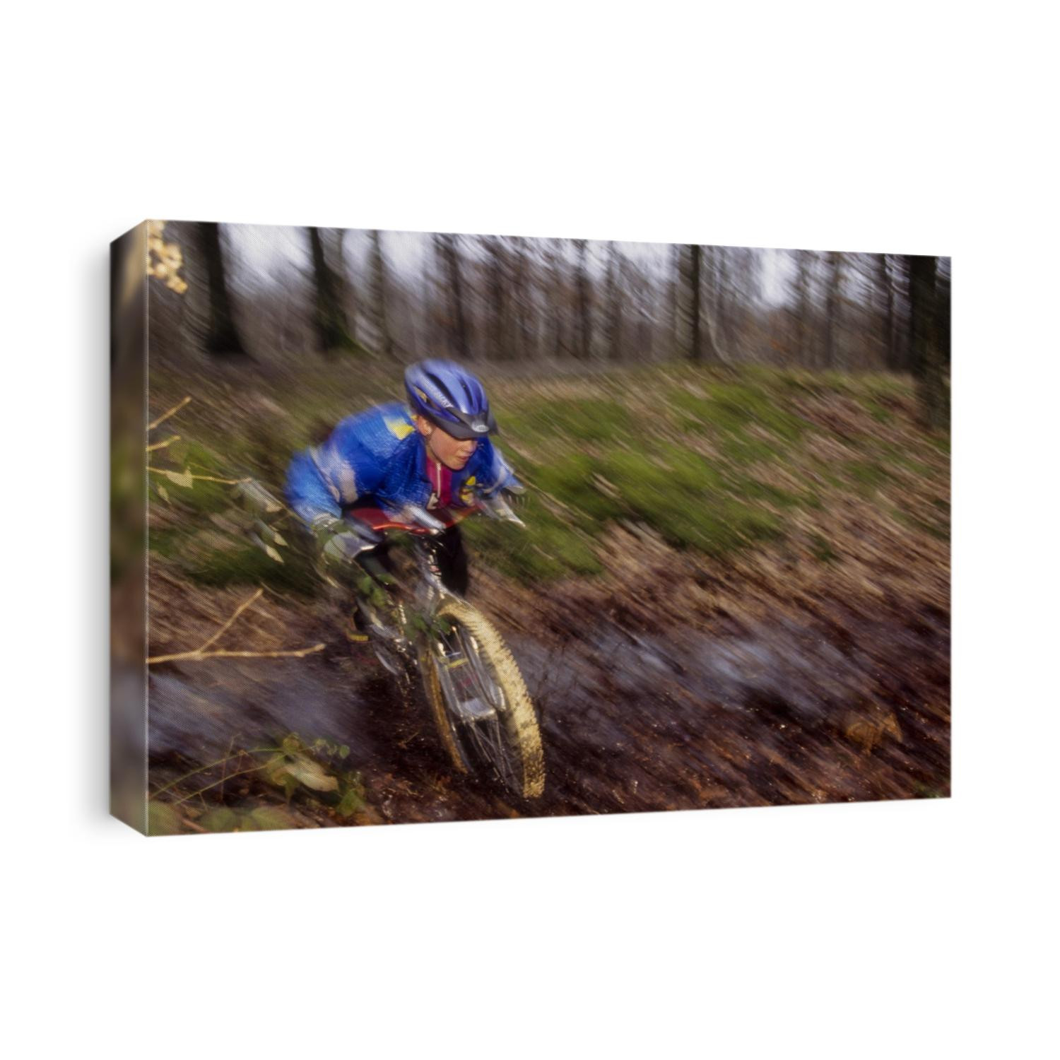 Young male recreational mountain biker riding in the forest.