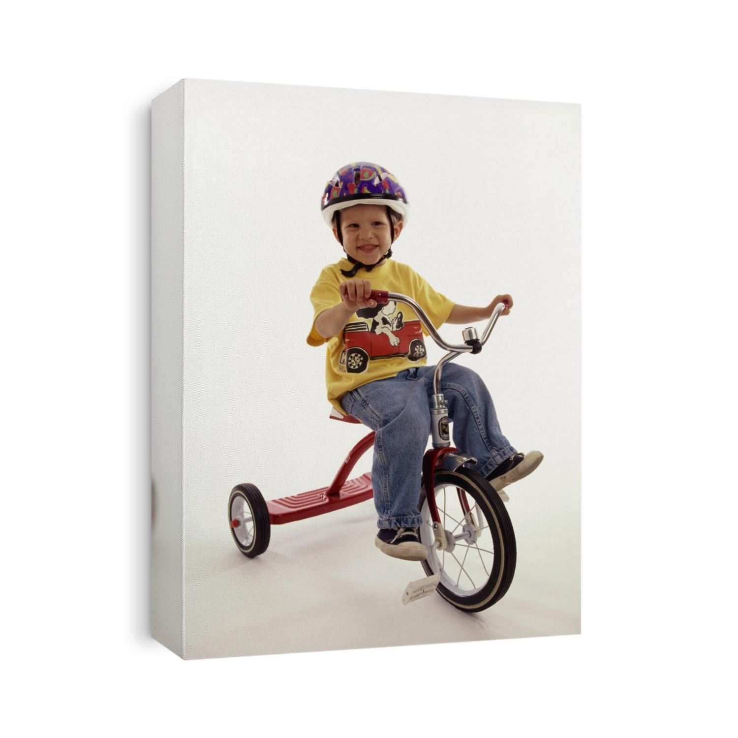 4 year old boy posing on his tricycle.