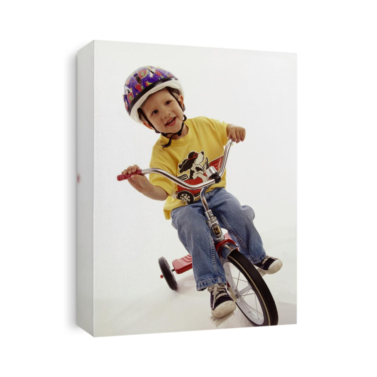 4 year old boy posing on his tricycle.
