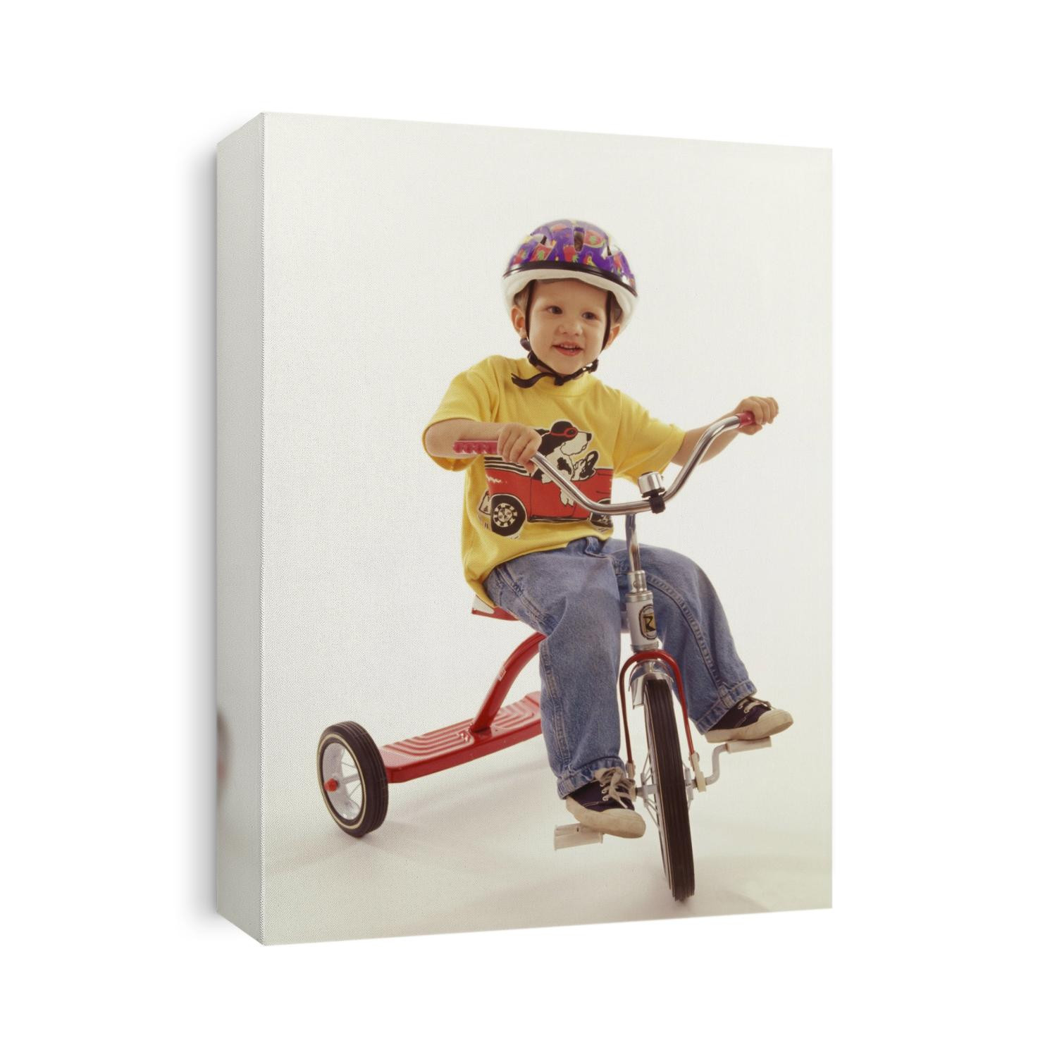 4 year old boy posing on his tricycle.