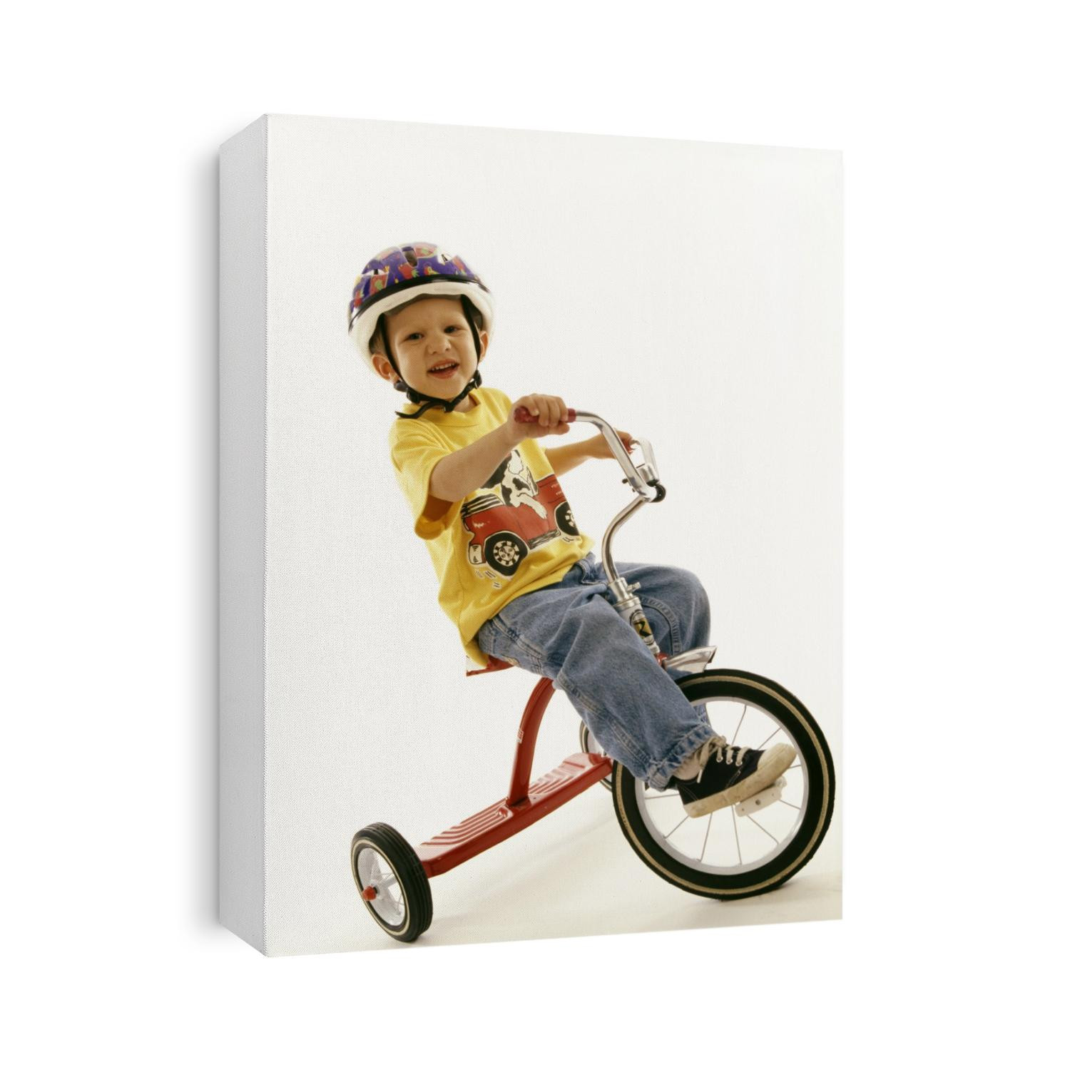 Portait of four year old boy on his tricycle.