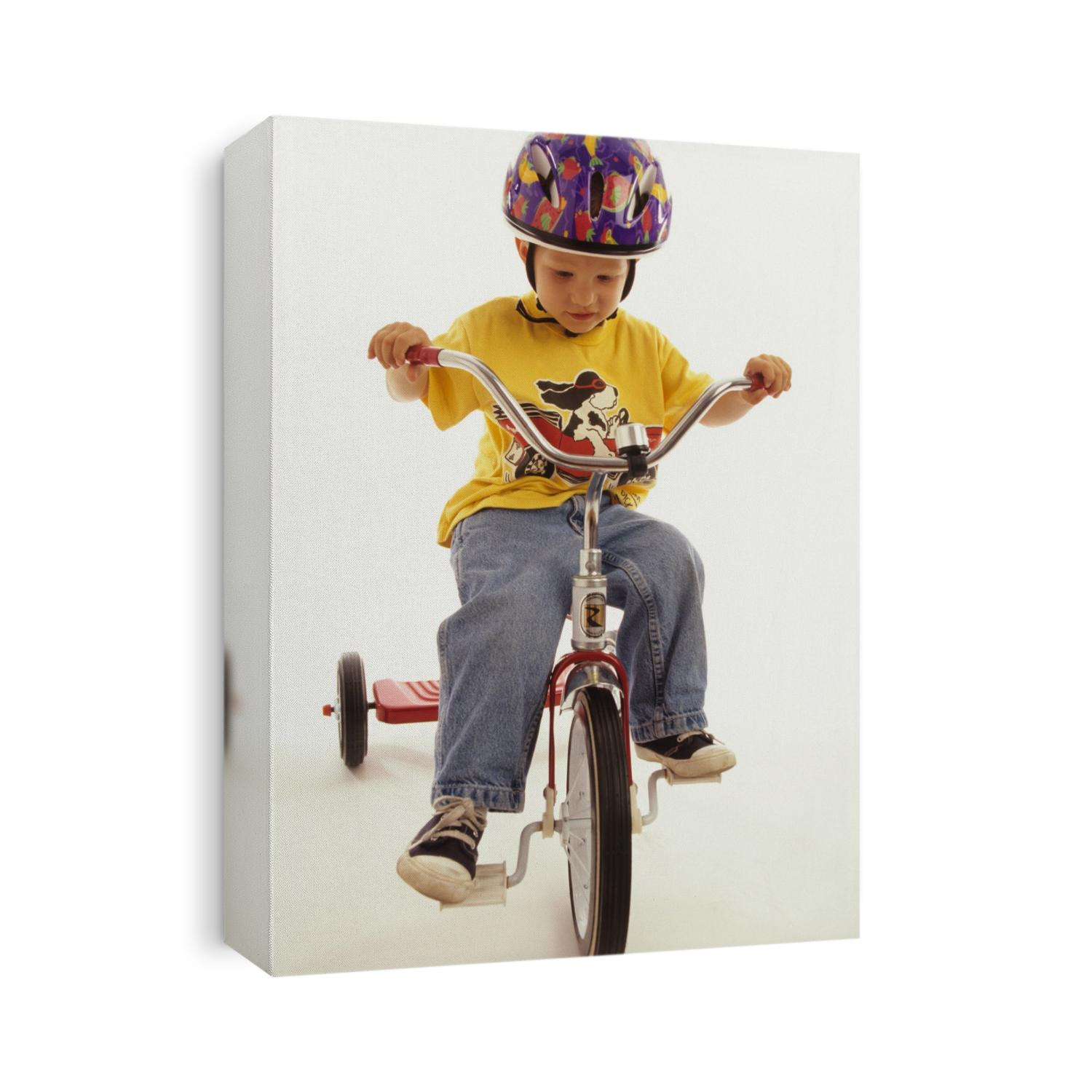 4 year old boy posing on his tricycle