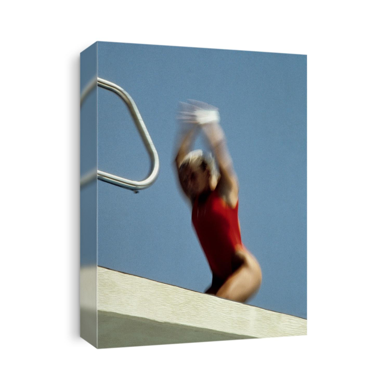 Blurred action of female diver taking off from the 10 meter platform.