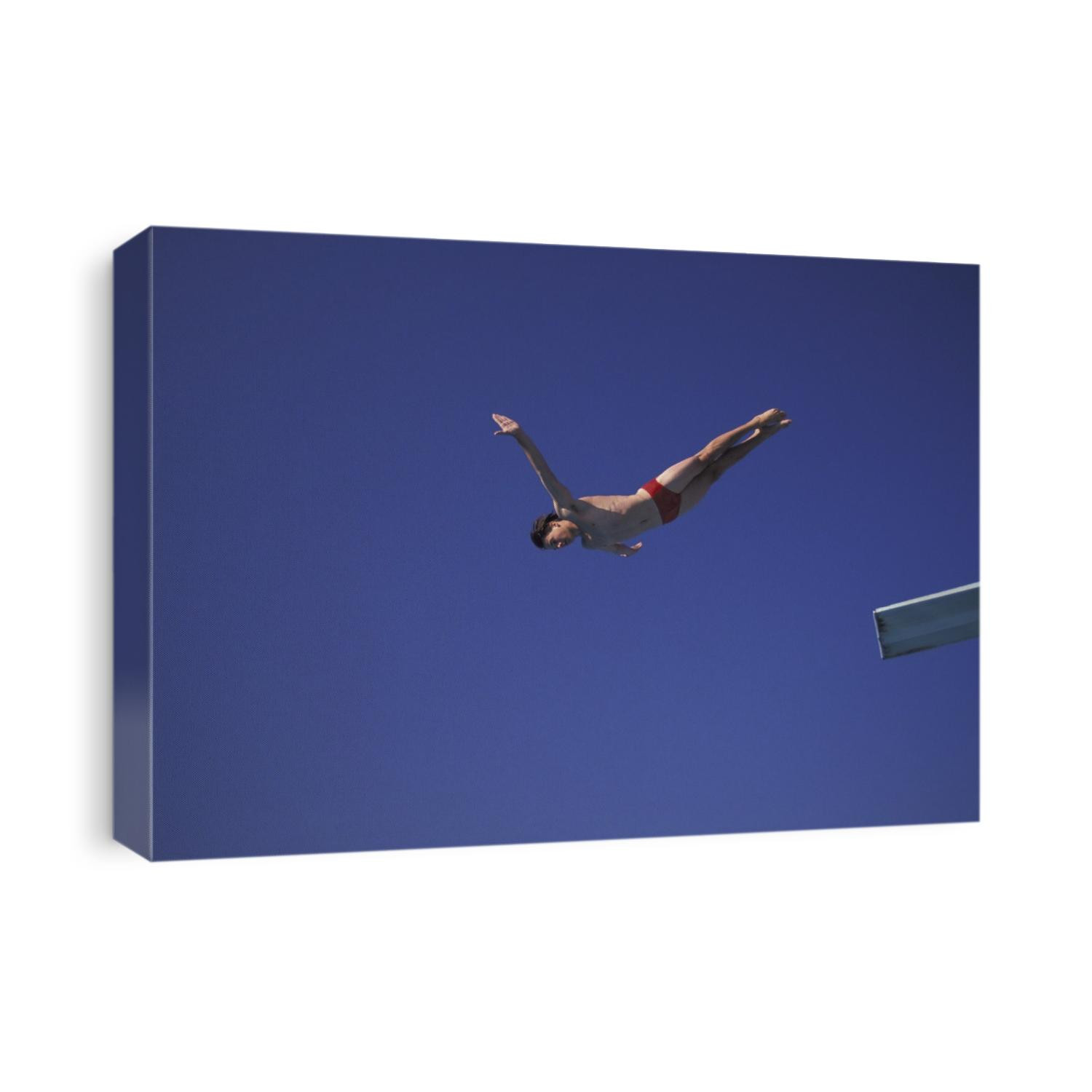 Young male diver flying off the springboard.