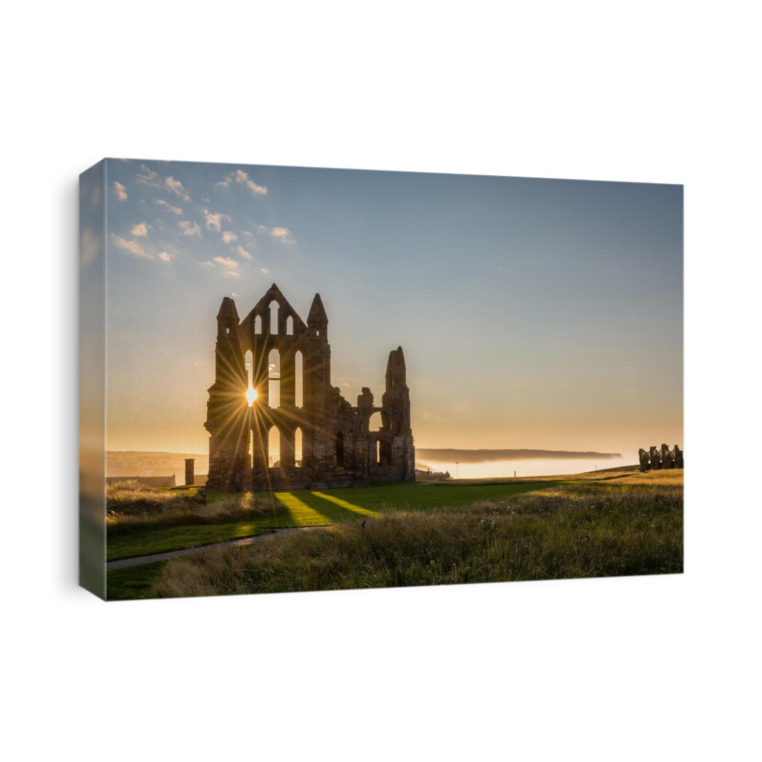 Sun Star on Whitby Abbey / The Gothic ruins of Whitby Abbey with the suns rays producing a star.  Sea mist held back by the cliffs at Sandsend in the background