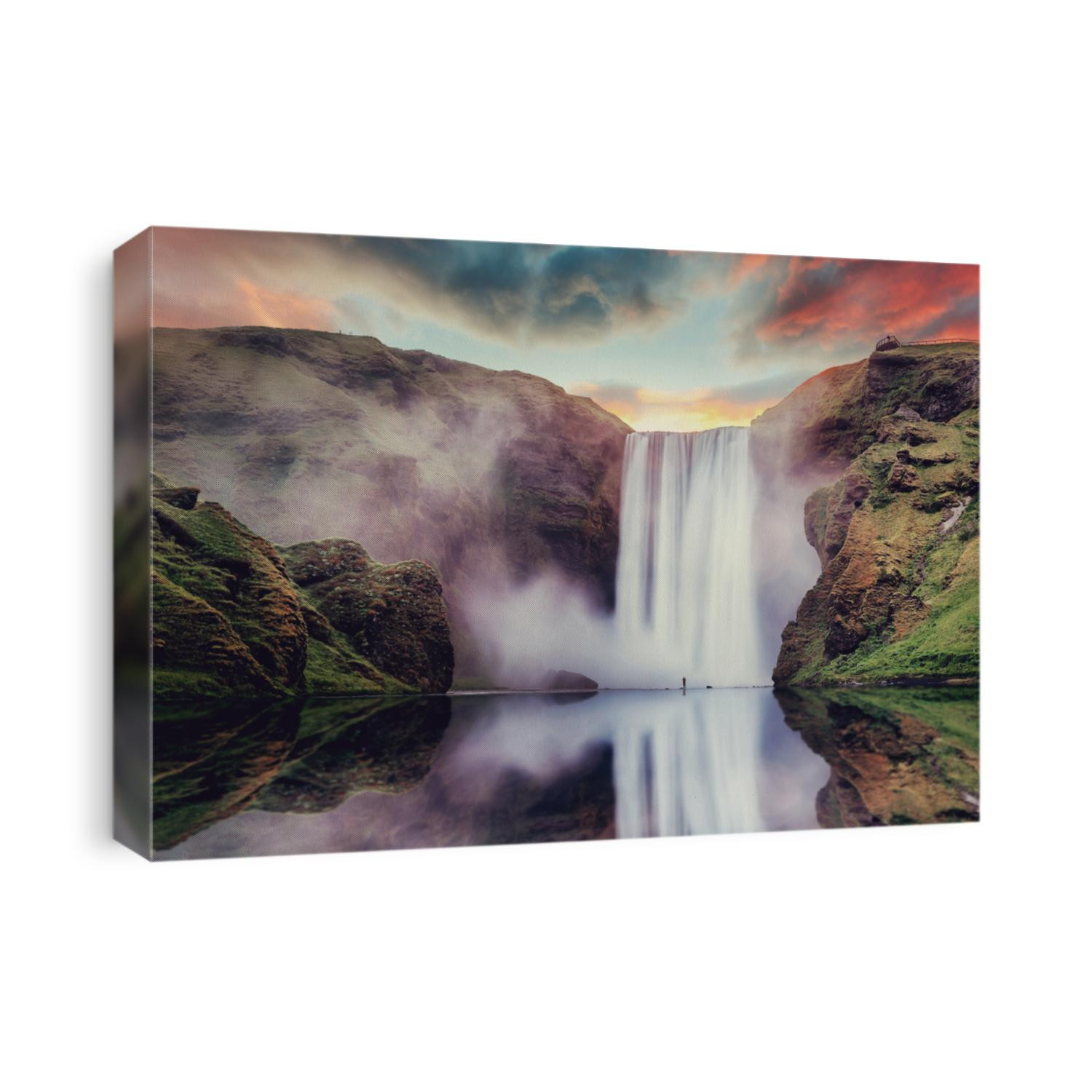 Icelandic Landscape. Classic long exposure view of famous Skogafoss waterfall with reflections. Dramatic Scenery of Iceland during sunset. majestic Skogafoss Waterfall in countryside with colorful sky