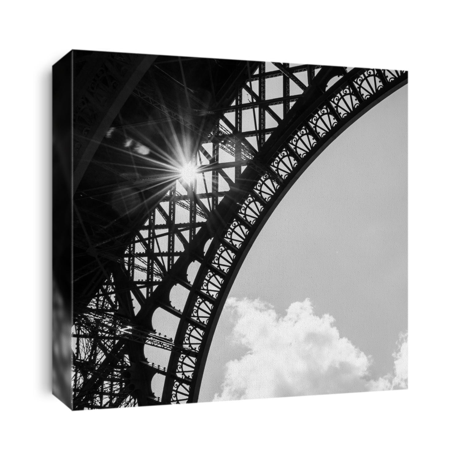 Sun shining through Eiffel Tower. Sun beams and spots. Aged photo. Black and white.