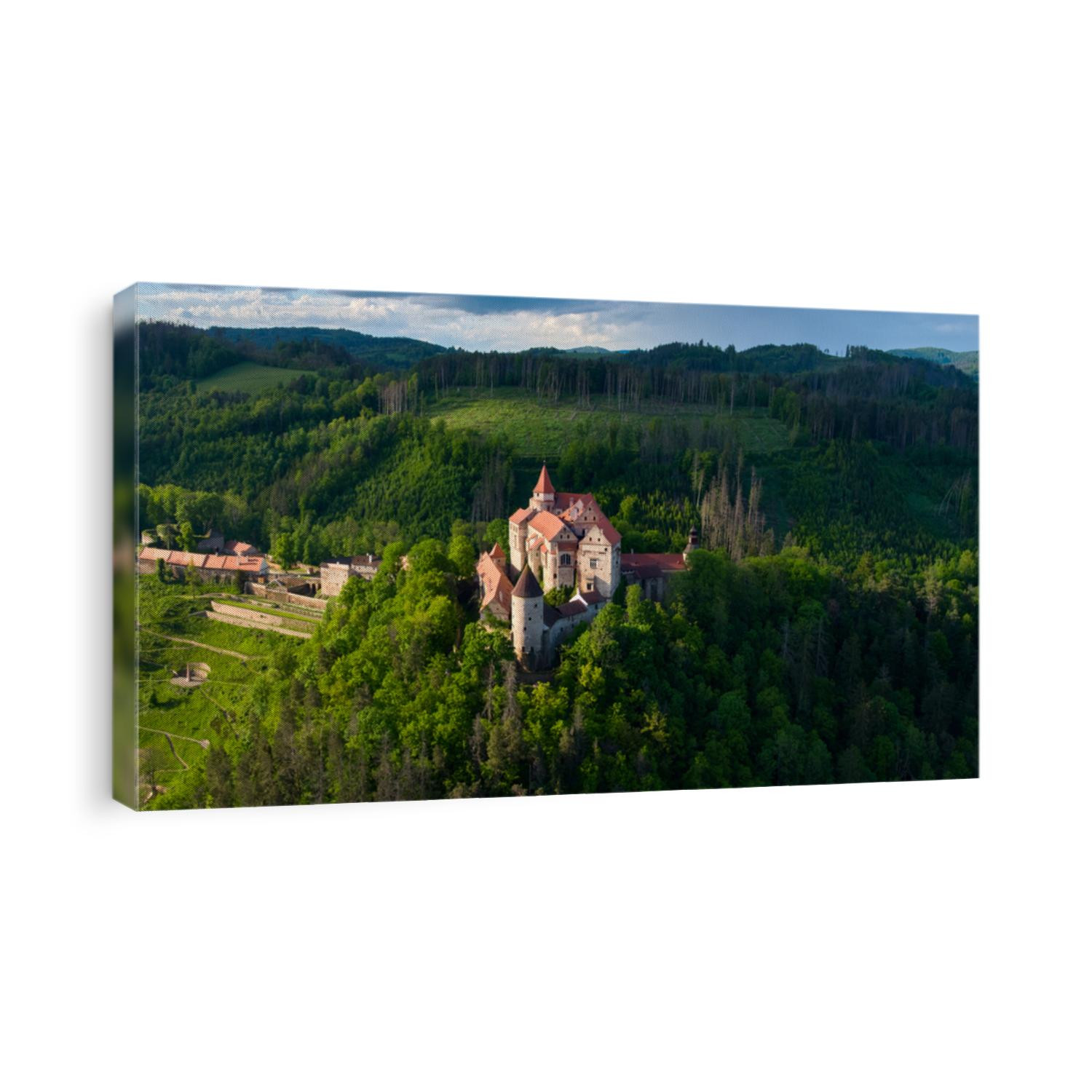 Panoramic, aerial view of ancient royal Moravian castle Pernstejn with new Vrchnostenska garden, illuminated by sun against dark forest. Aerial photography. Bohemian-Moravian Highlands, Czech castles