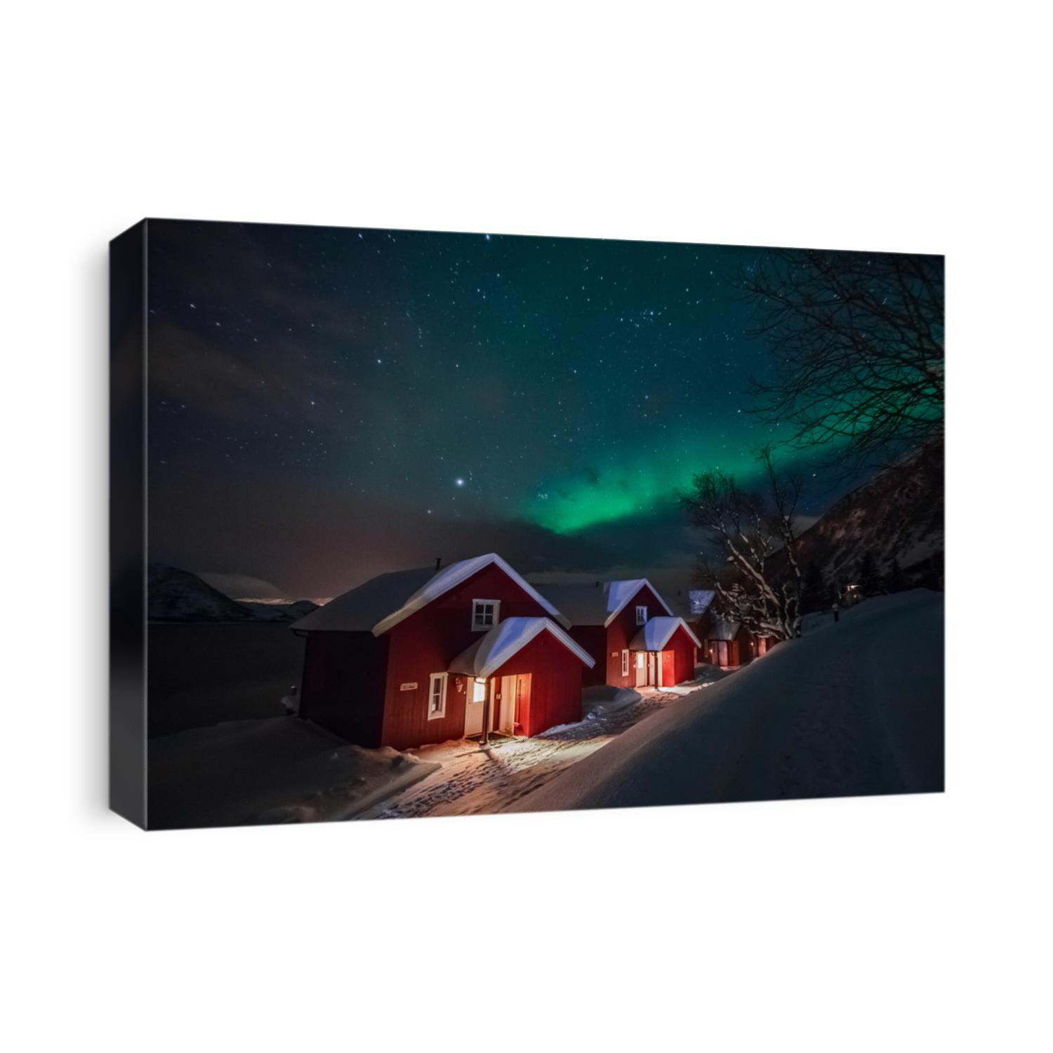 Northern lights (Aurora Borealis) over the red snowed-in cottages in Lapland village
