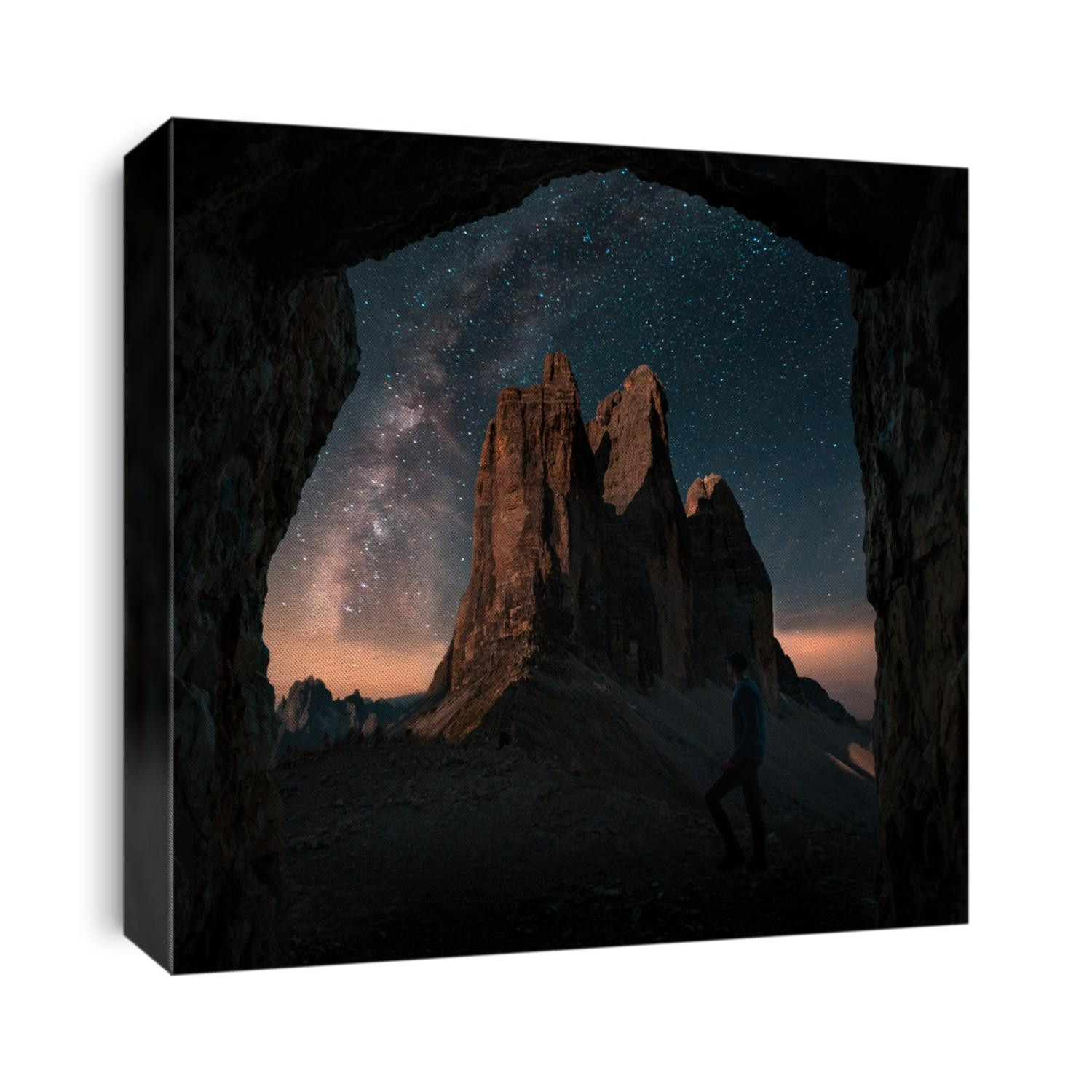 Boy, man is standing in front of moutains Tre Cime di Lavaredo in Dolomites, Italy during night with full of stars and Milky way. Amazing landscape night photo with atmosphere. 