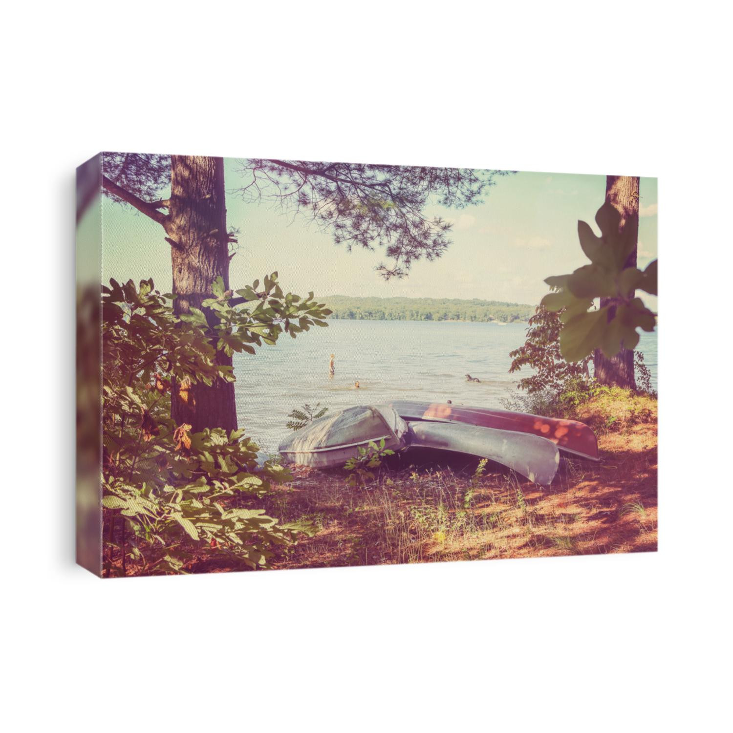 Canoes pulled up on the shore, with kids playing in the lake. Vintage Instagram effect.