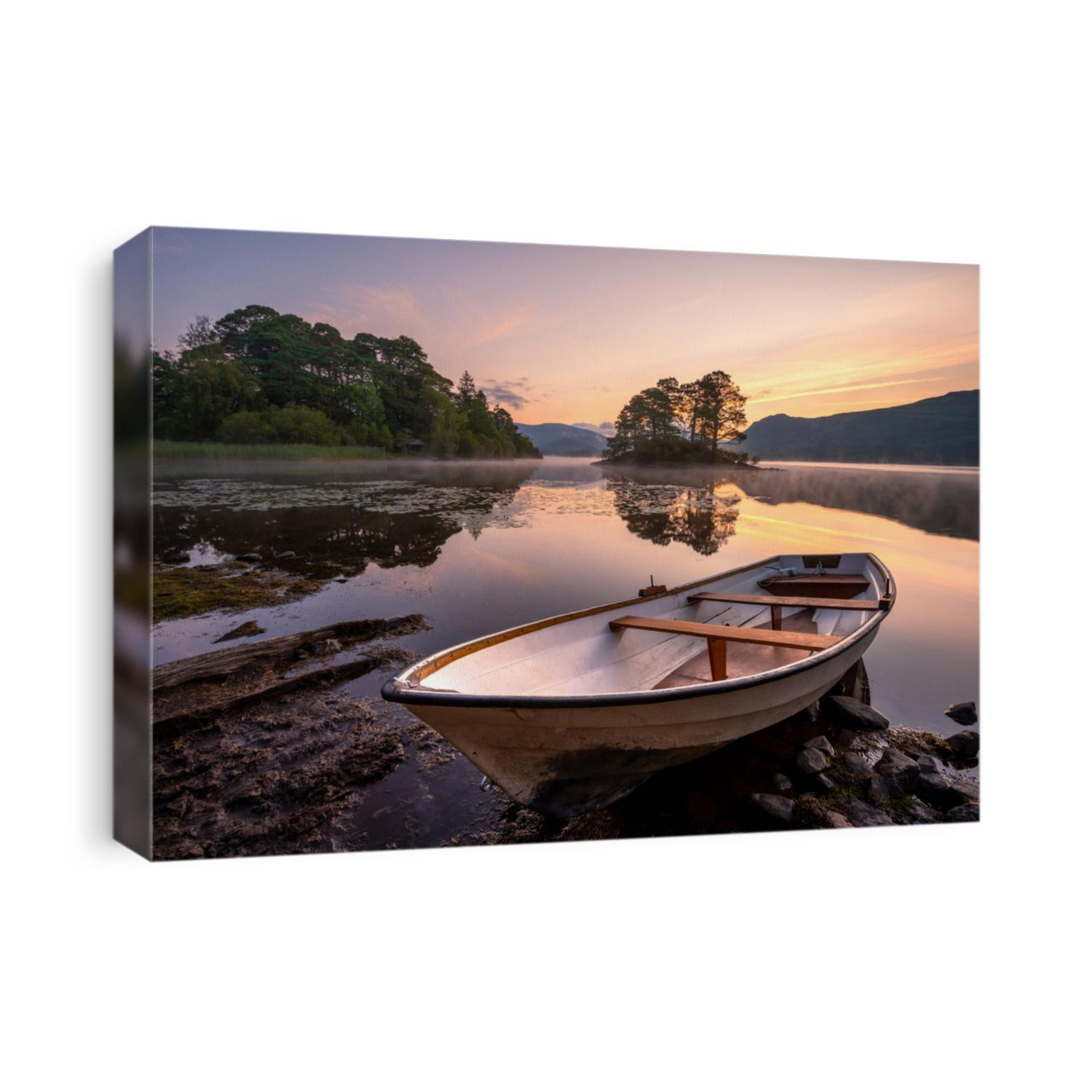 Wooden rowing boat on lake shoreline with beautiful view of calm misty Derwentwater in the Lake District, UK. Travel background of British Summer landscape.